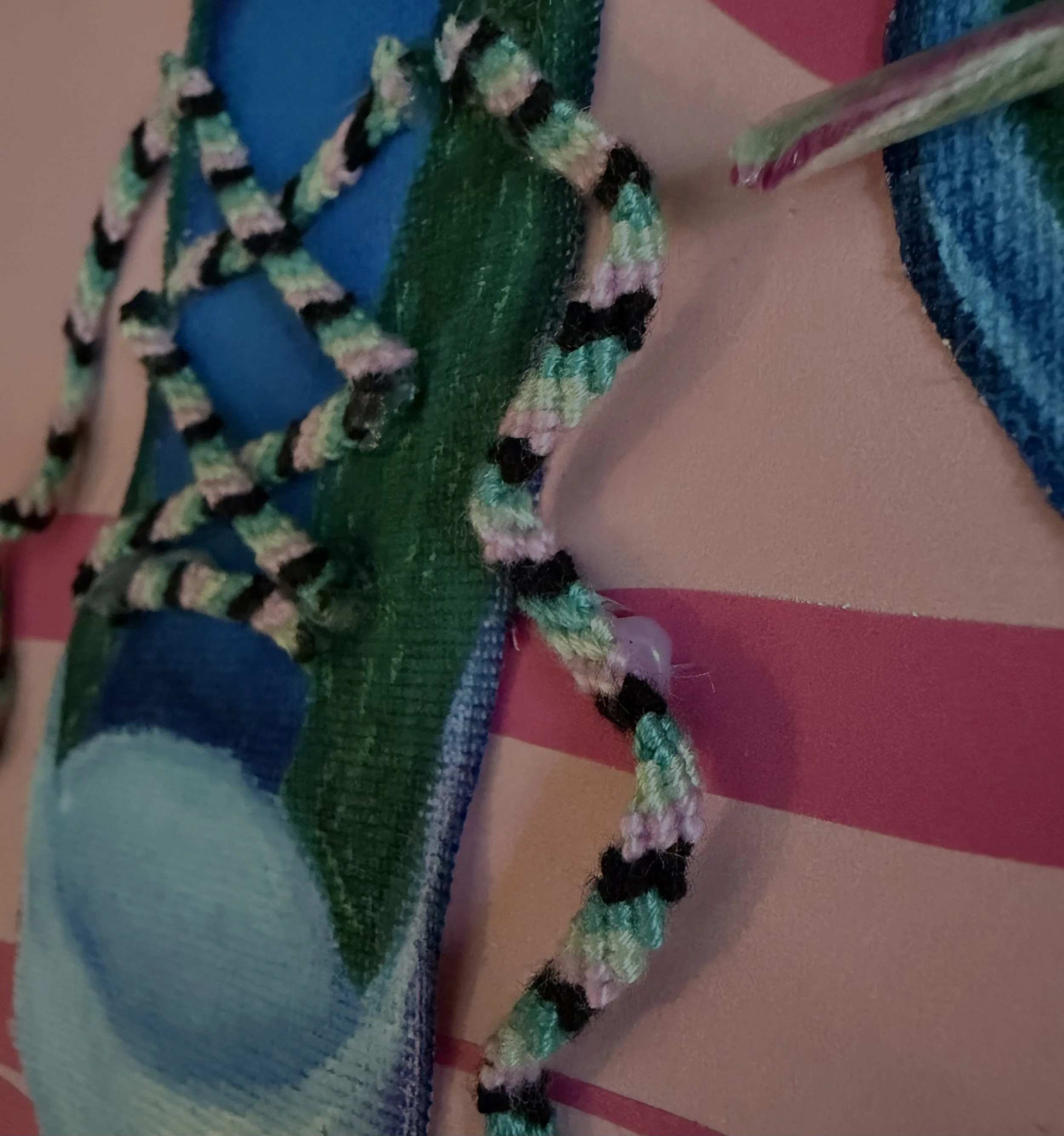 Close-up of a painting of a shoe with textured shoelaces.