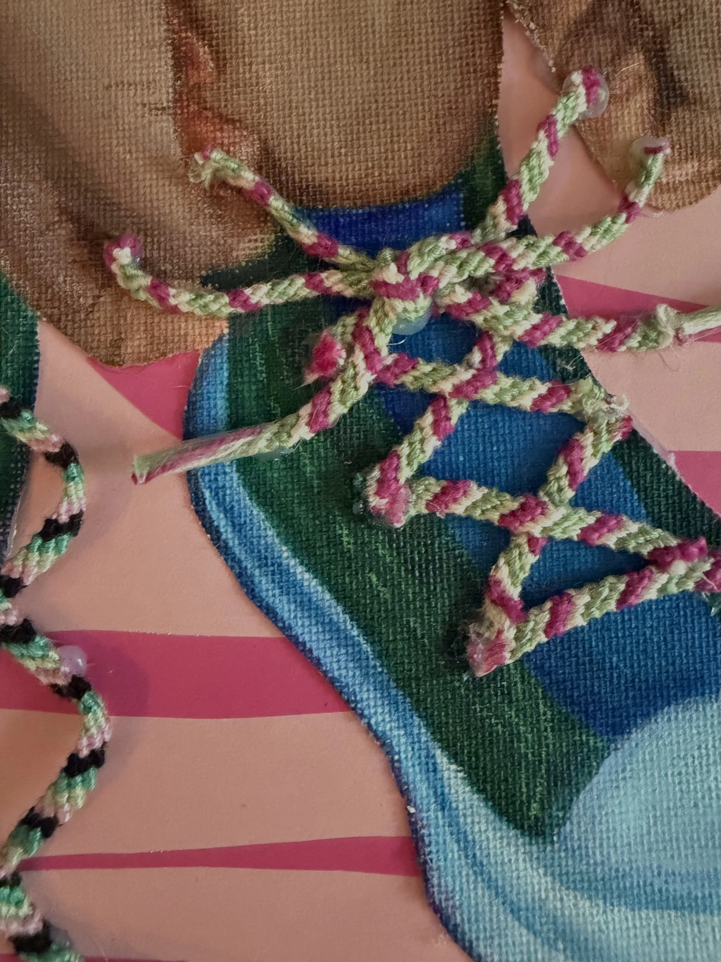 Close-up photograph of colorful shoelaces intertwined on a multicolored fabric surface with pink, blue, brown, green, and black elements.