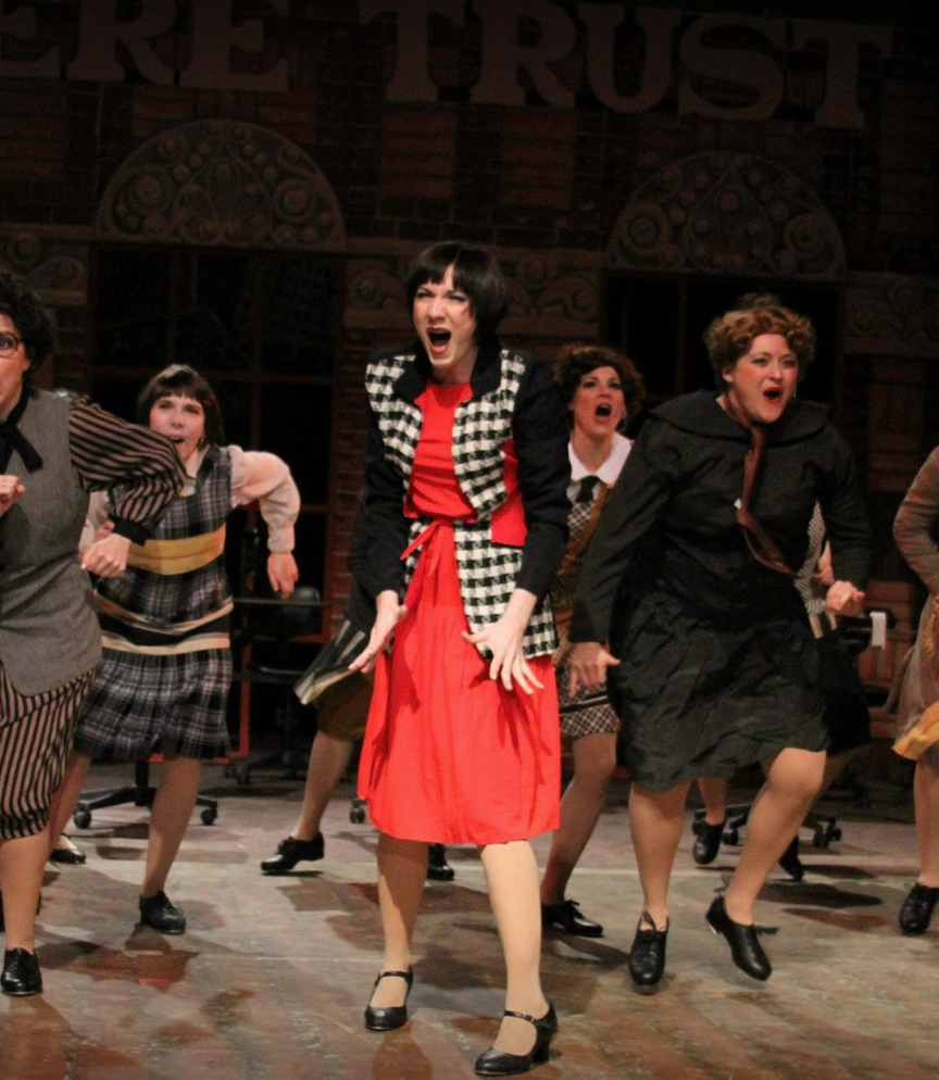 And as Millie, Sara Burke is sensationally adorkable. She’s quirky, energetic, and beautiful. With a wink, a smile, and a crinkle of the nose, she gives a plucky charm to the role. I’ve seen many Millie’s in the last ten years, and none have been as 