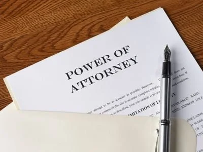 Legal documents labeled 'Power of Attorney' with a fountain pen resting on top.