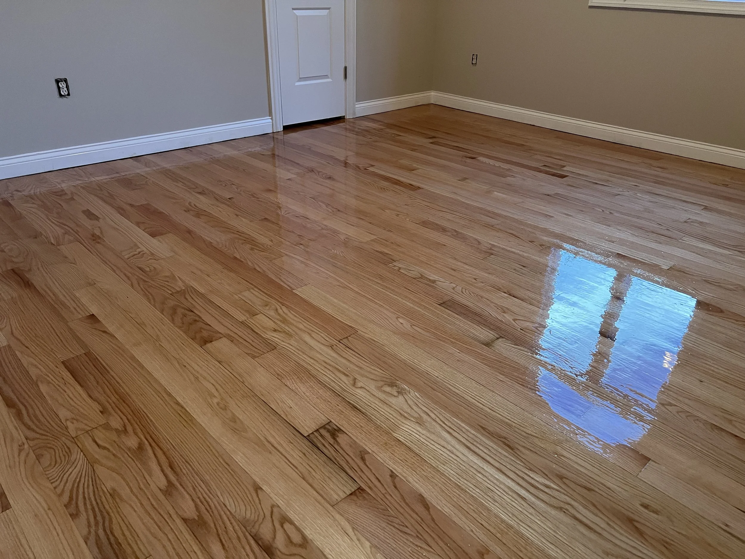Refinished hardwood floor with restored color and protective finish