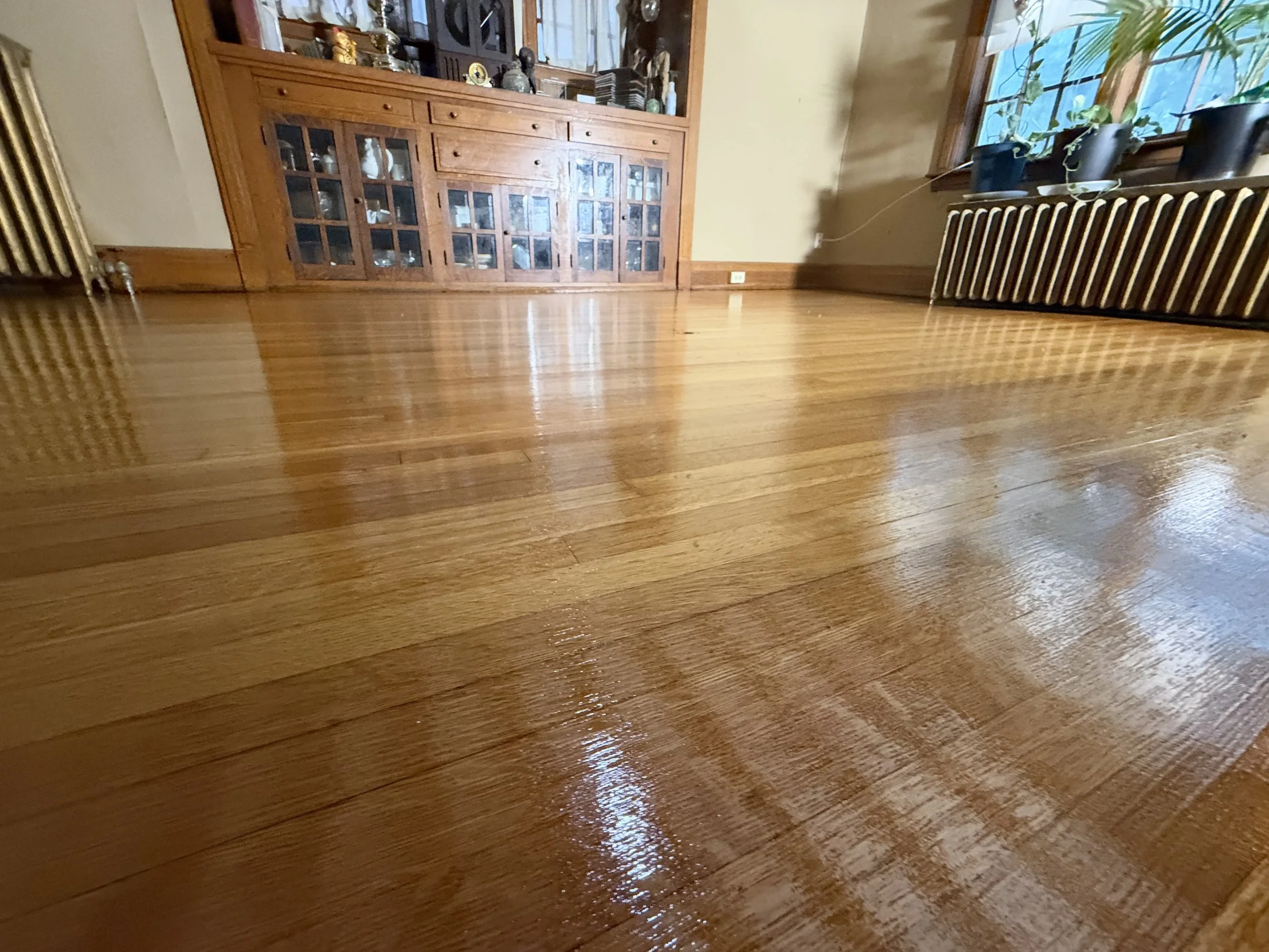 Hardwood floor refinished with a renewed even tone and protective finish in a Plano, Illinois home