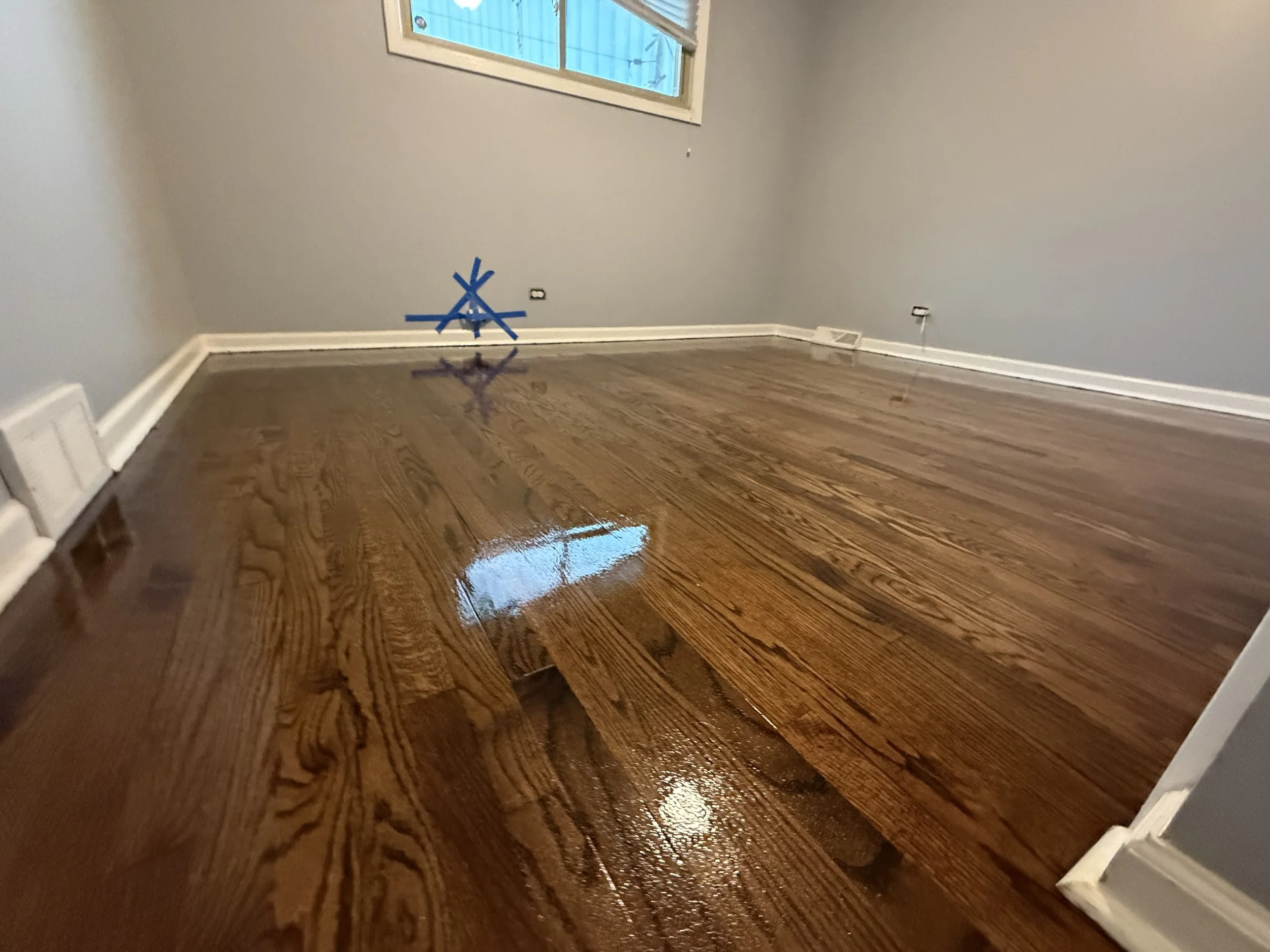 Refinished hardwood flooring with restored color and a durable protective finish in a DeKalb home