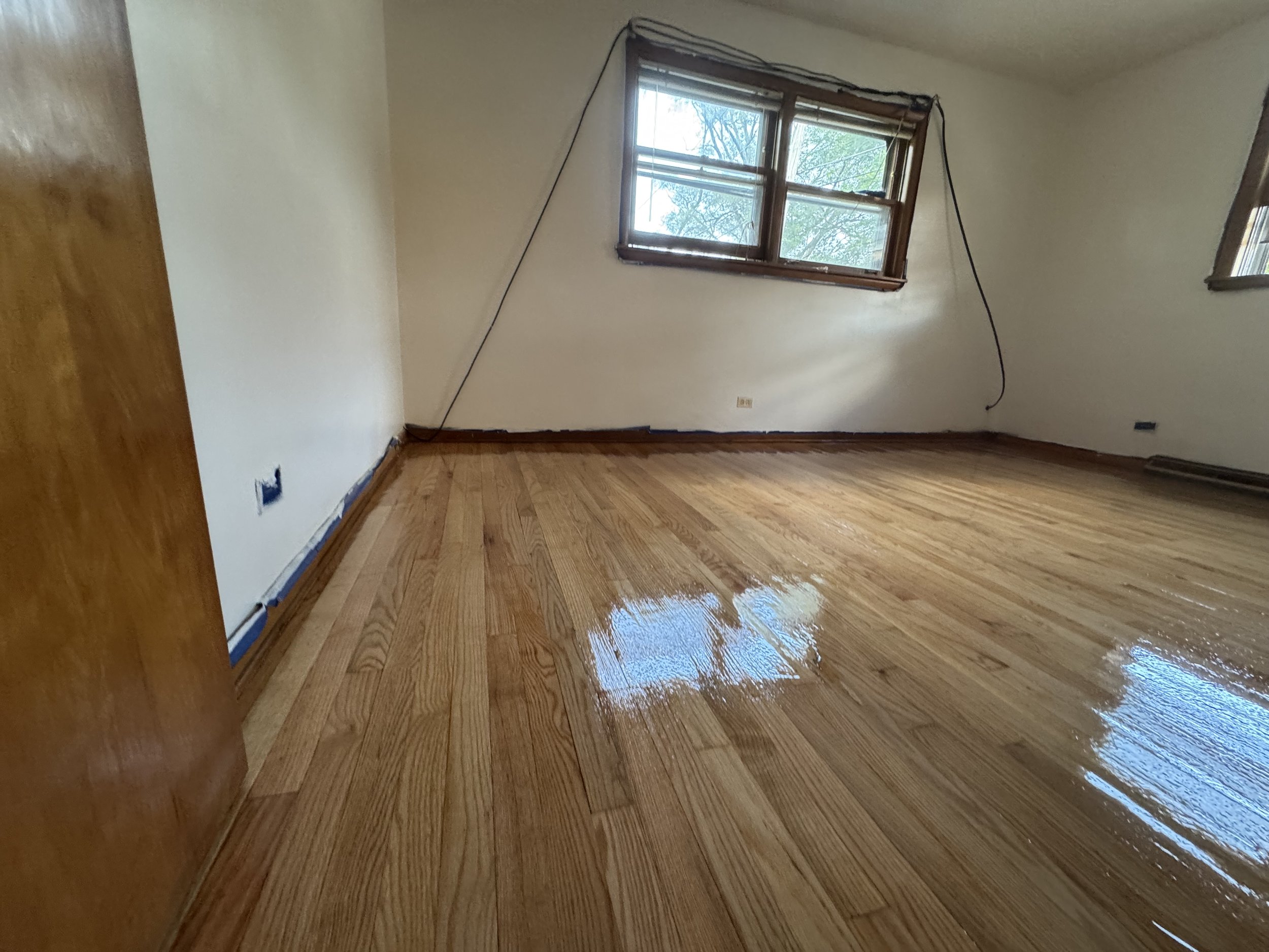 Refinished hardwood floor with restored natural color and a durable protective finish in a Crestwood home