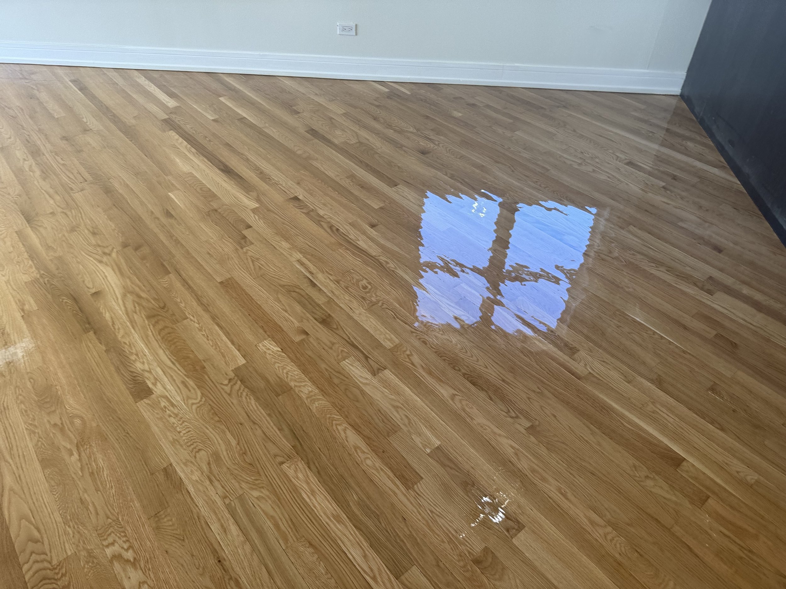 Refinished hardwood flooring with restored natural color and durable protective finish in a Joliet home