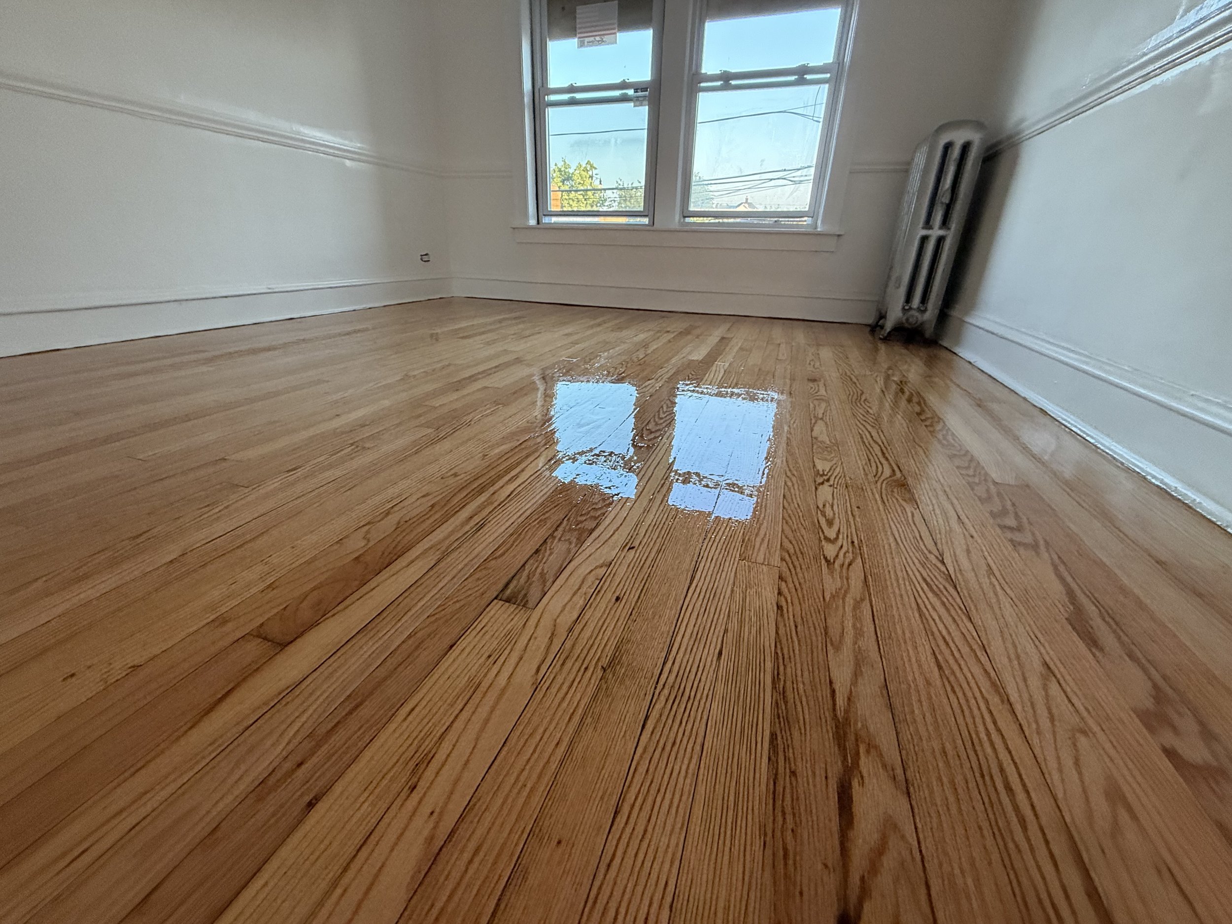 Refinished hardwood floor with restored color and a durable clear protective finish in a Newark home