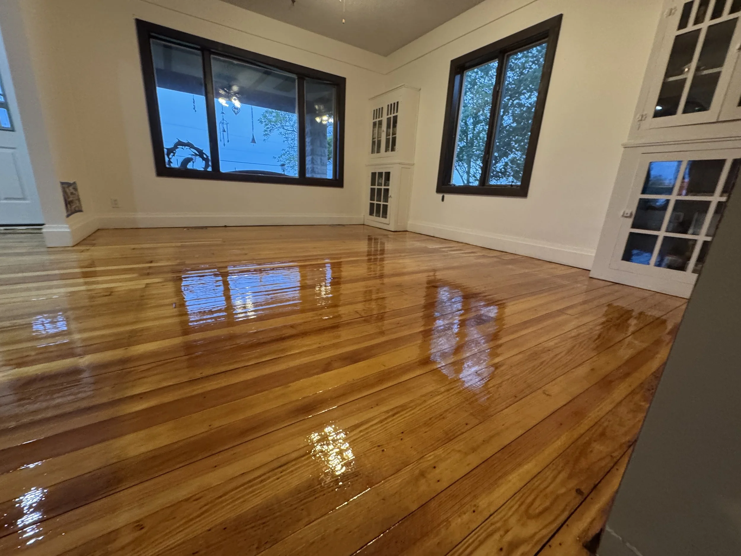 Refinished hardwood flooring with a clean natural appearance and durable clear protective coat in a Lee home