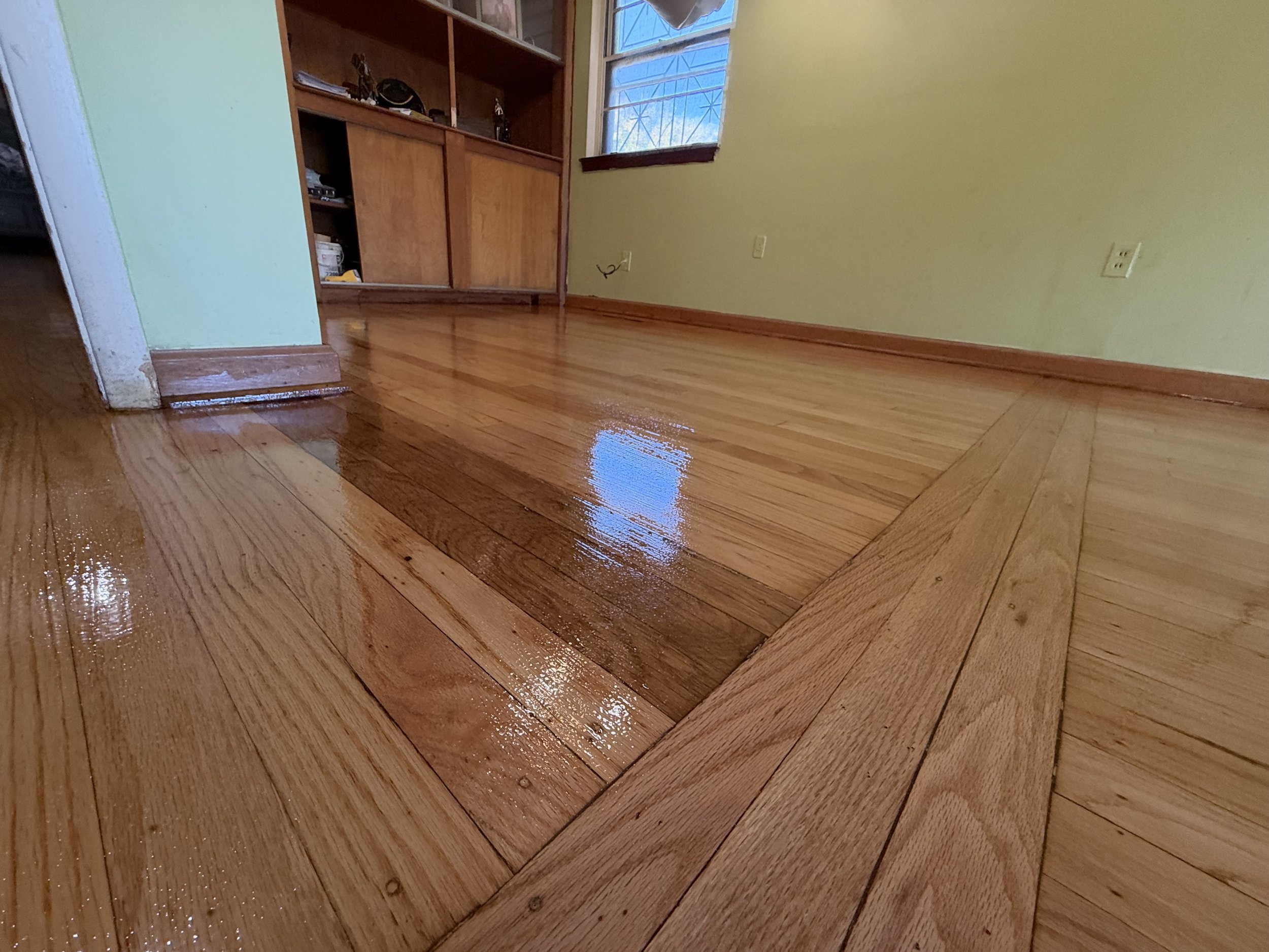 Hardwood floor refinished to restore its smooth surface, natural grain, and rich wood color