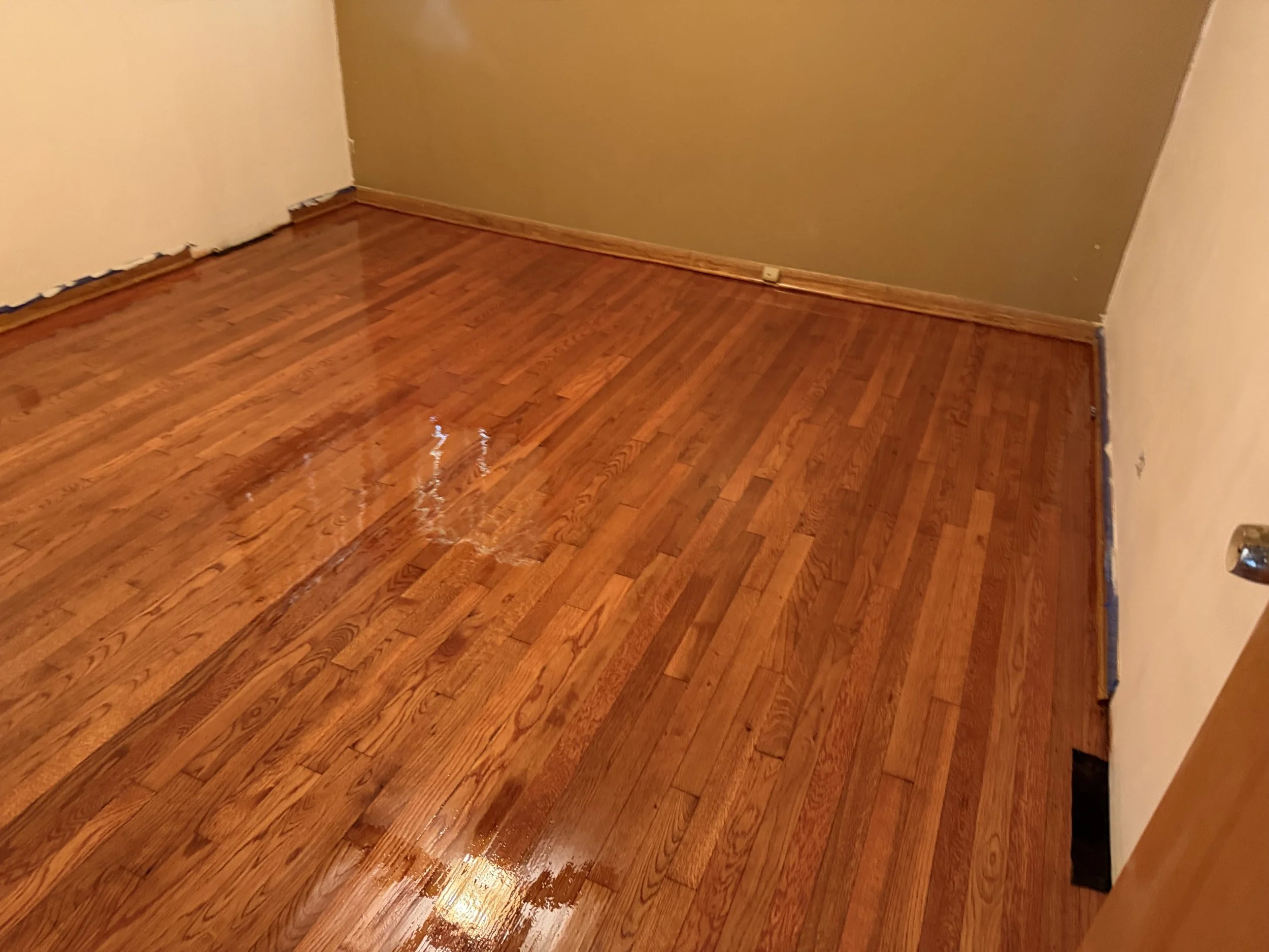 Refinished hardwood flooring with restored natural color and a durable protective finish in a Bedford Park home