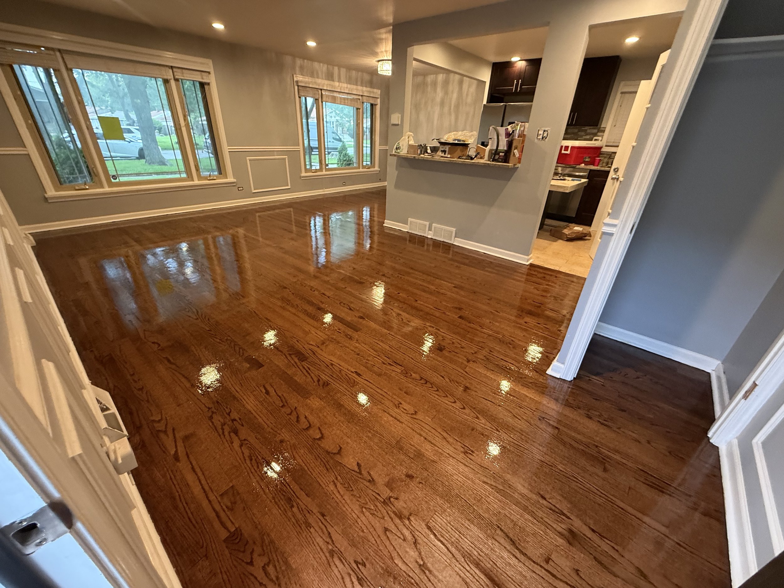 Refinished hardwood floor with restored natural color and a durable protective topcoat in a Serena home