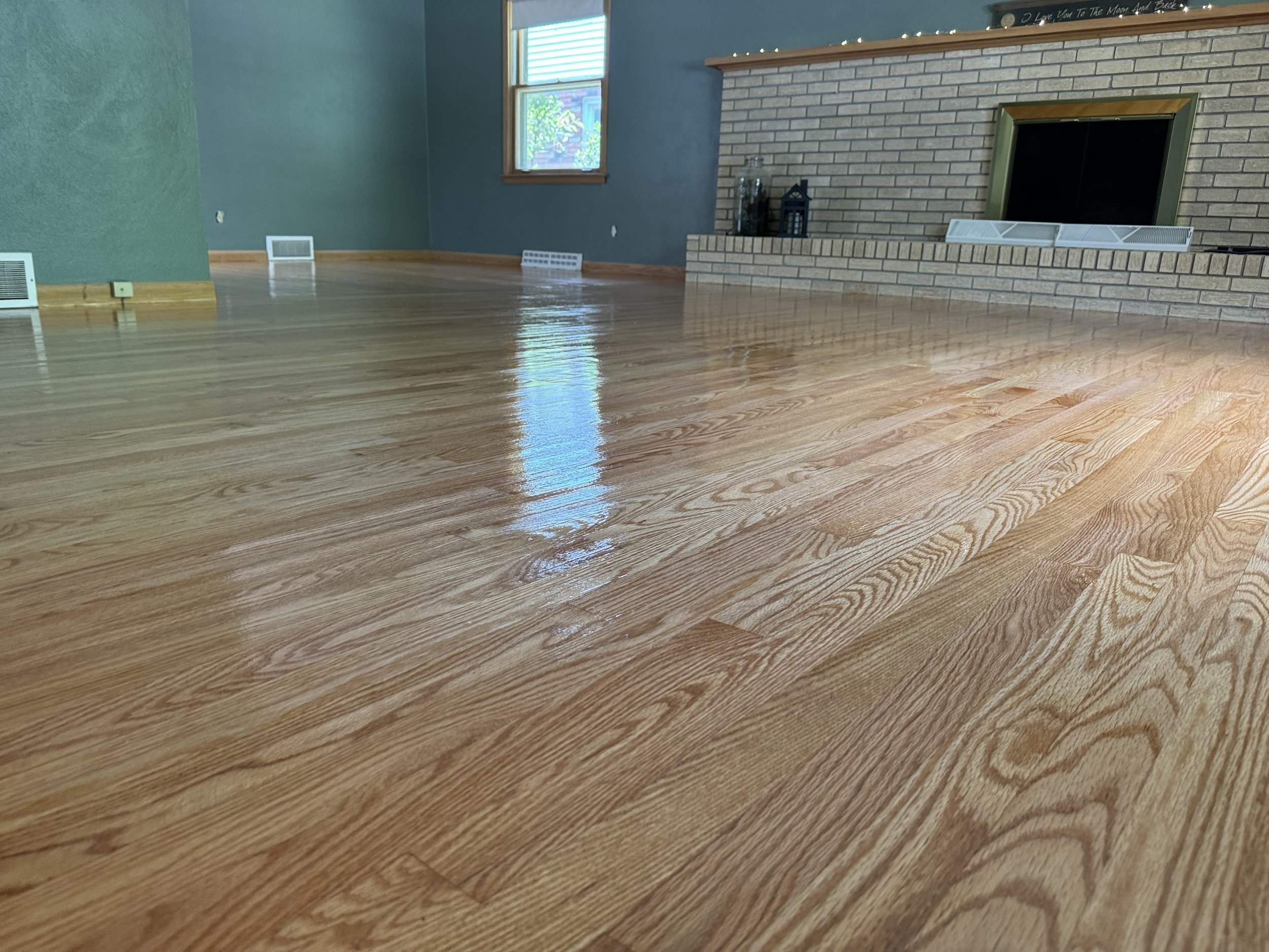 Refinished hardwood floor with an even color, smooth surface, and durable clear finish