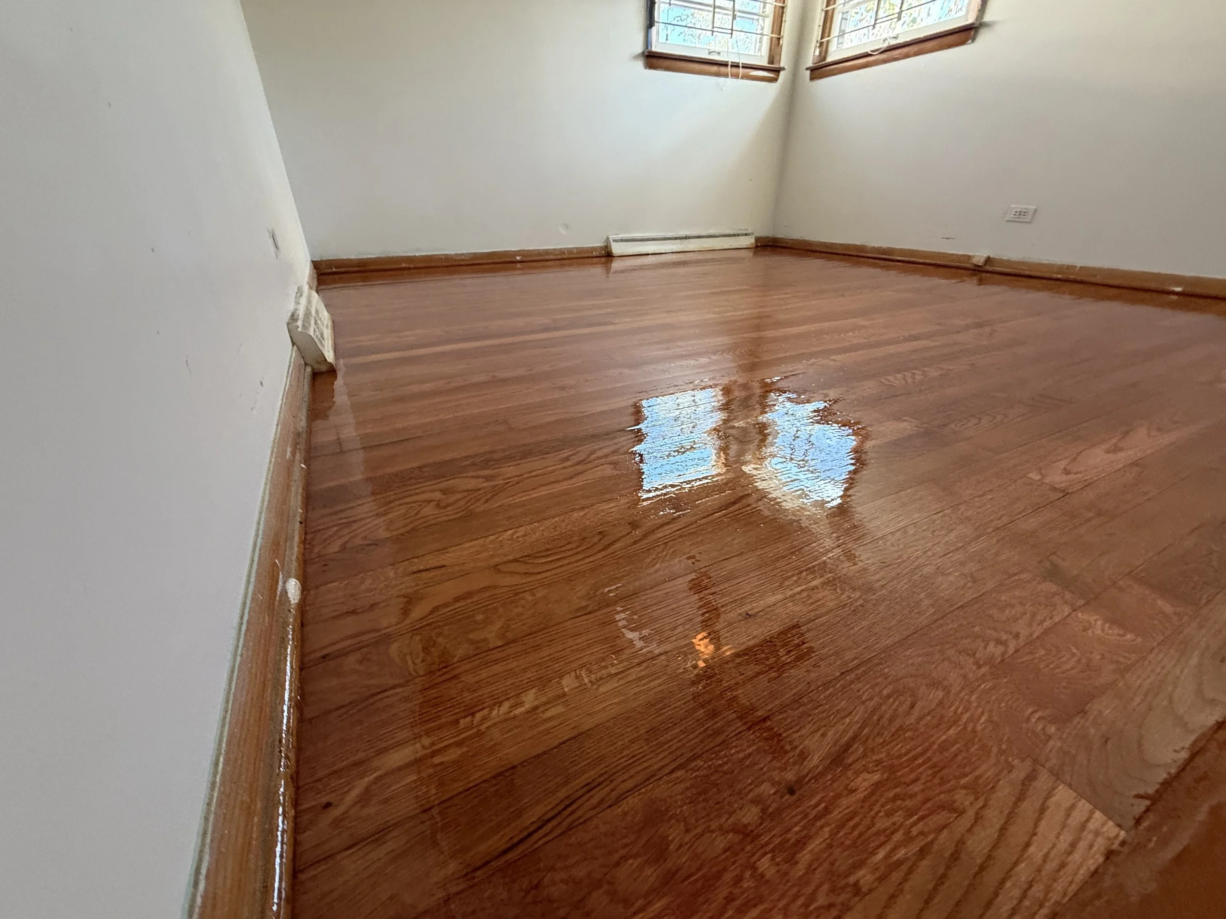 Refinished hardwood floor with a renewed smooth appearance and durable protective finish in a Sheridan home
