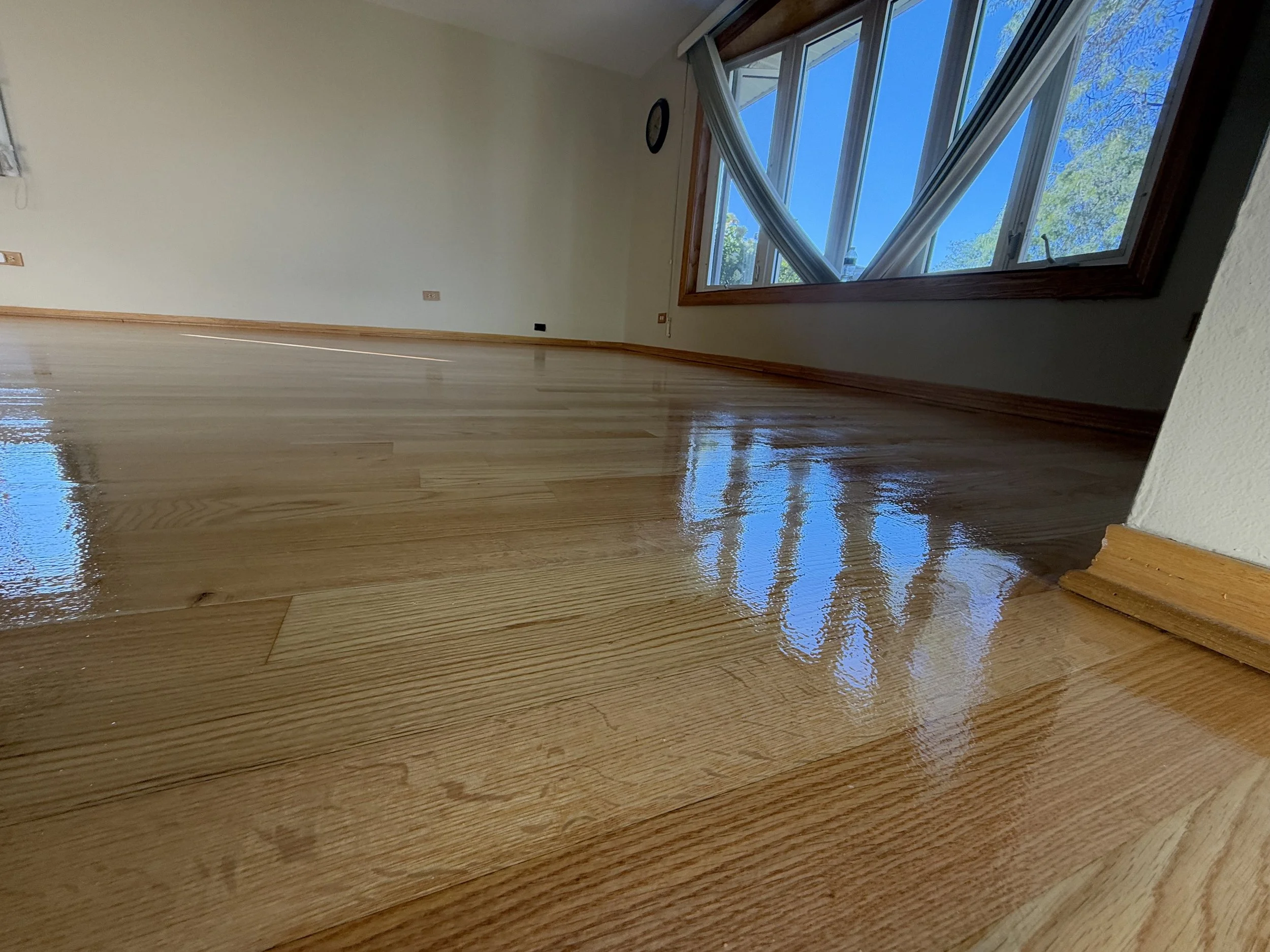 Refinished hardwood flooring with renewed color and protective coating in a St. Charles, Illinois home