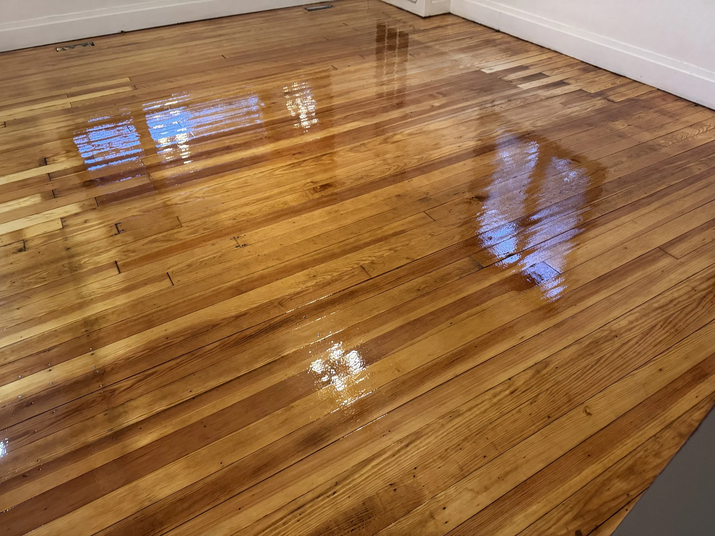 Refinished hardwood flooring with restored natural color and a durable protective topcoat in a Somonauk home