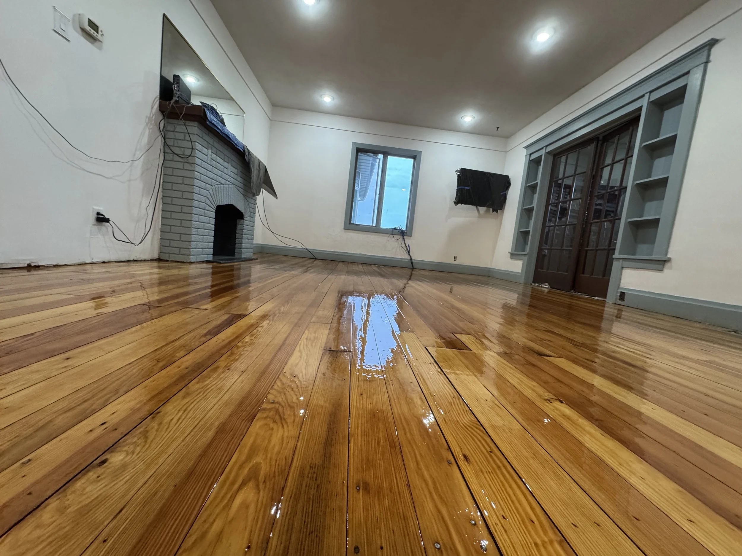Hardwood floor refinished to restore its warm wood tone and durable protective surface in a Steward home