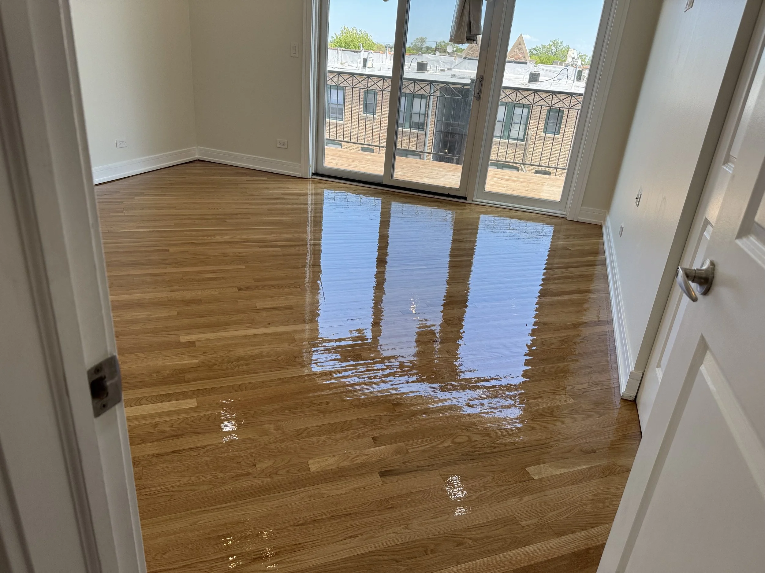 Refinished hardwood floor with renewed natural color and a durable protective finish in a Crest Hill home