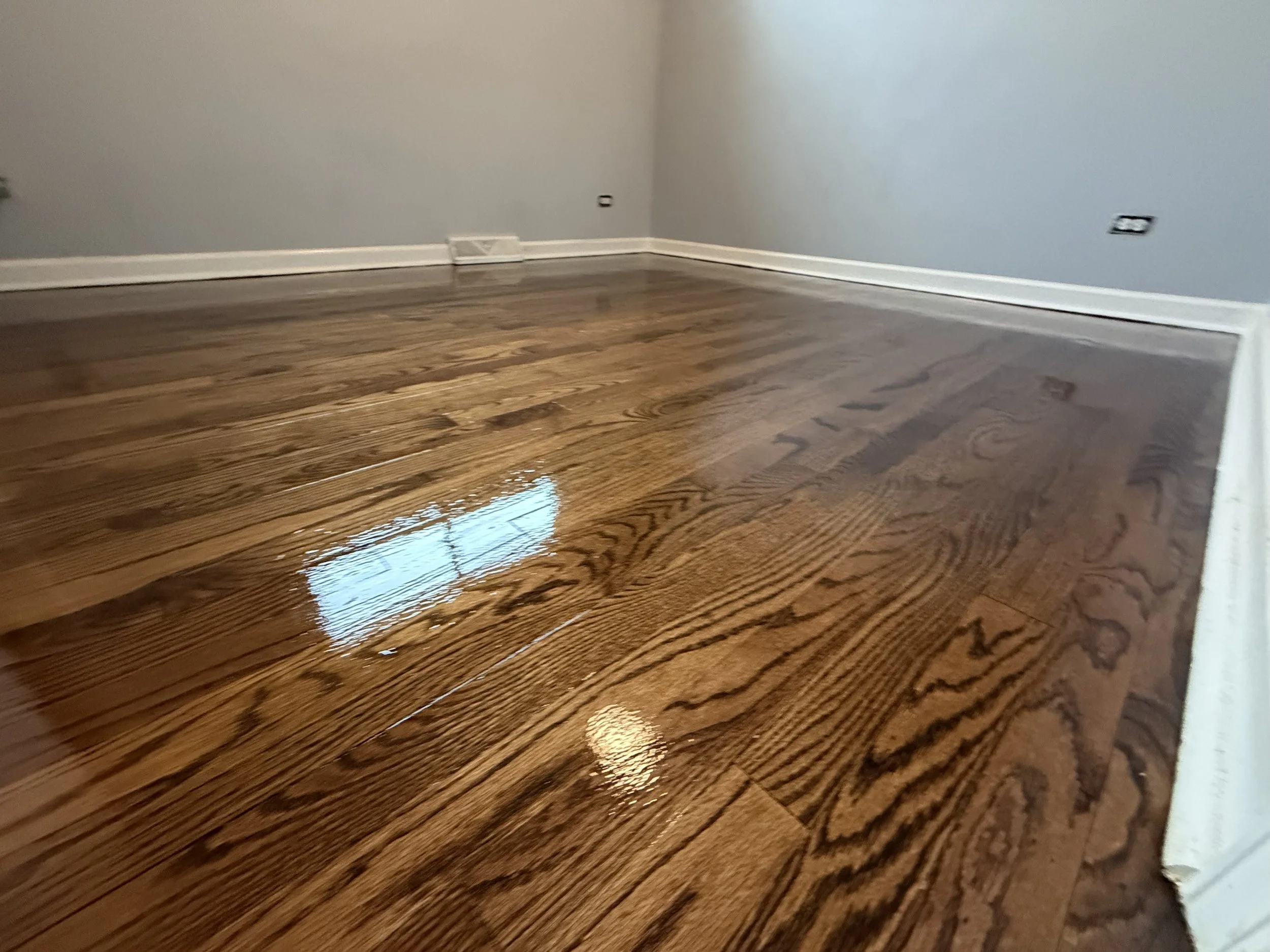 Hardwood floor refinished with an even color, smooth surface, and protective finish in a Cortland home