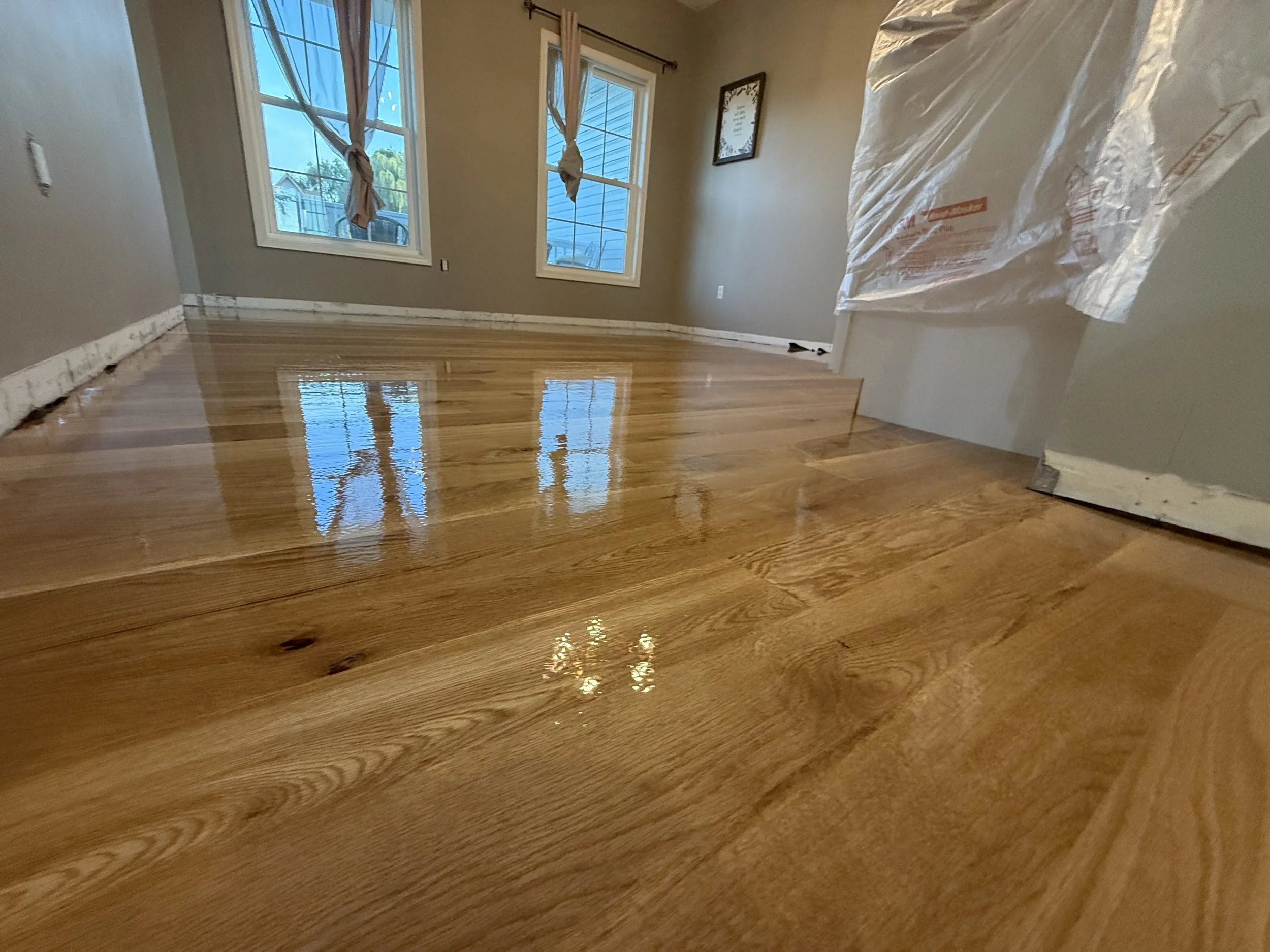Refinished hardwood floor with a refreshed natural color and durable protective finish in a Waterman home