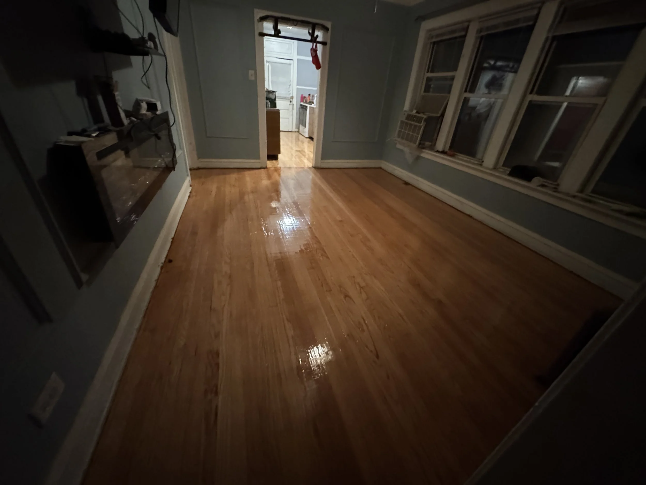 Refinished hardwood flooring with renewed natural color and a durable protective finish in a Paw Paw home