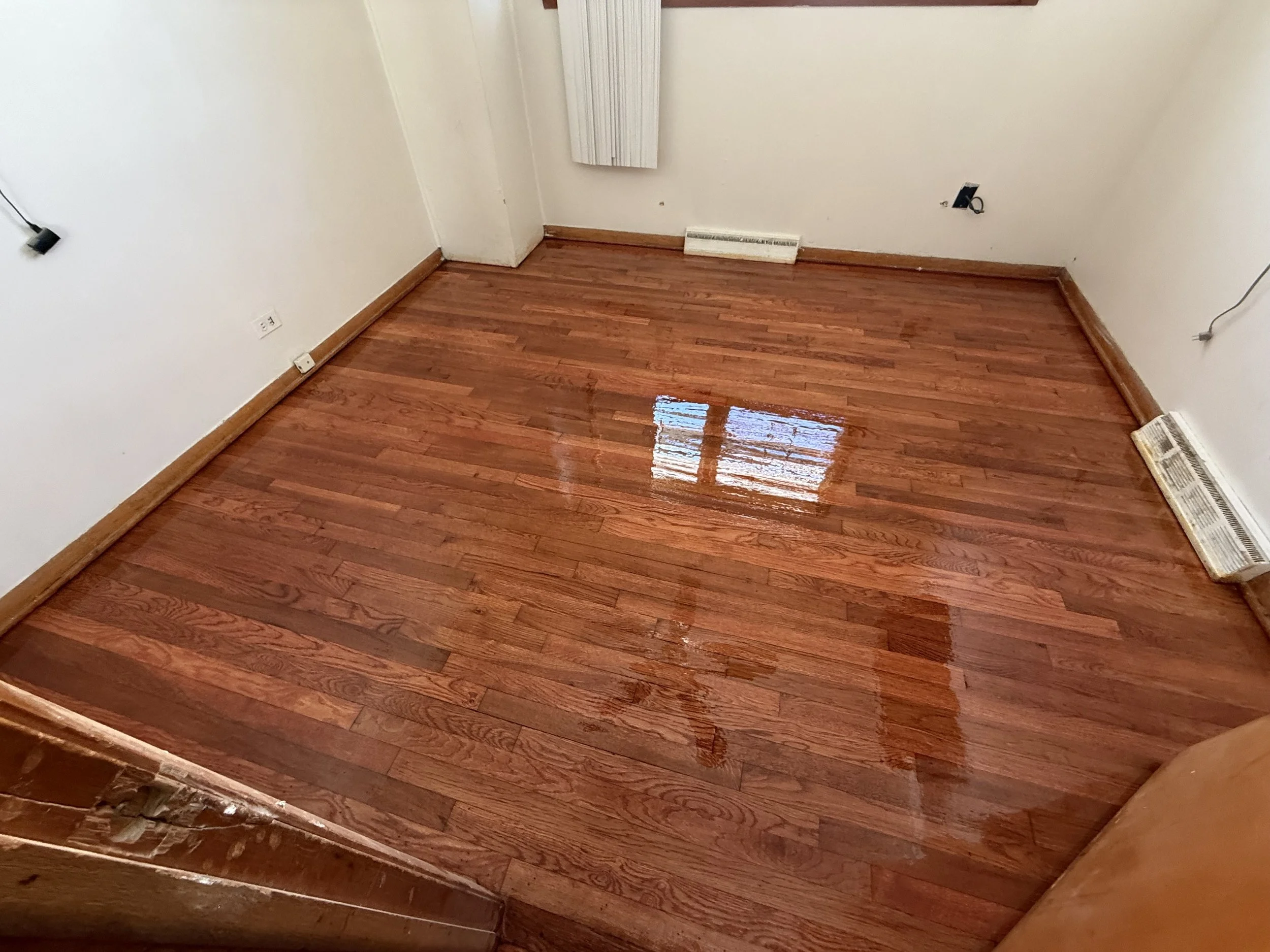 Refinished hardwood flooring with a smooth renewed surface and durable finish in a Rochelle home