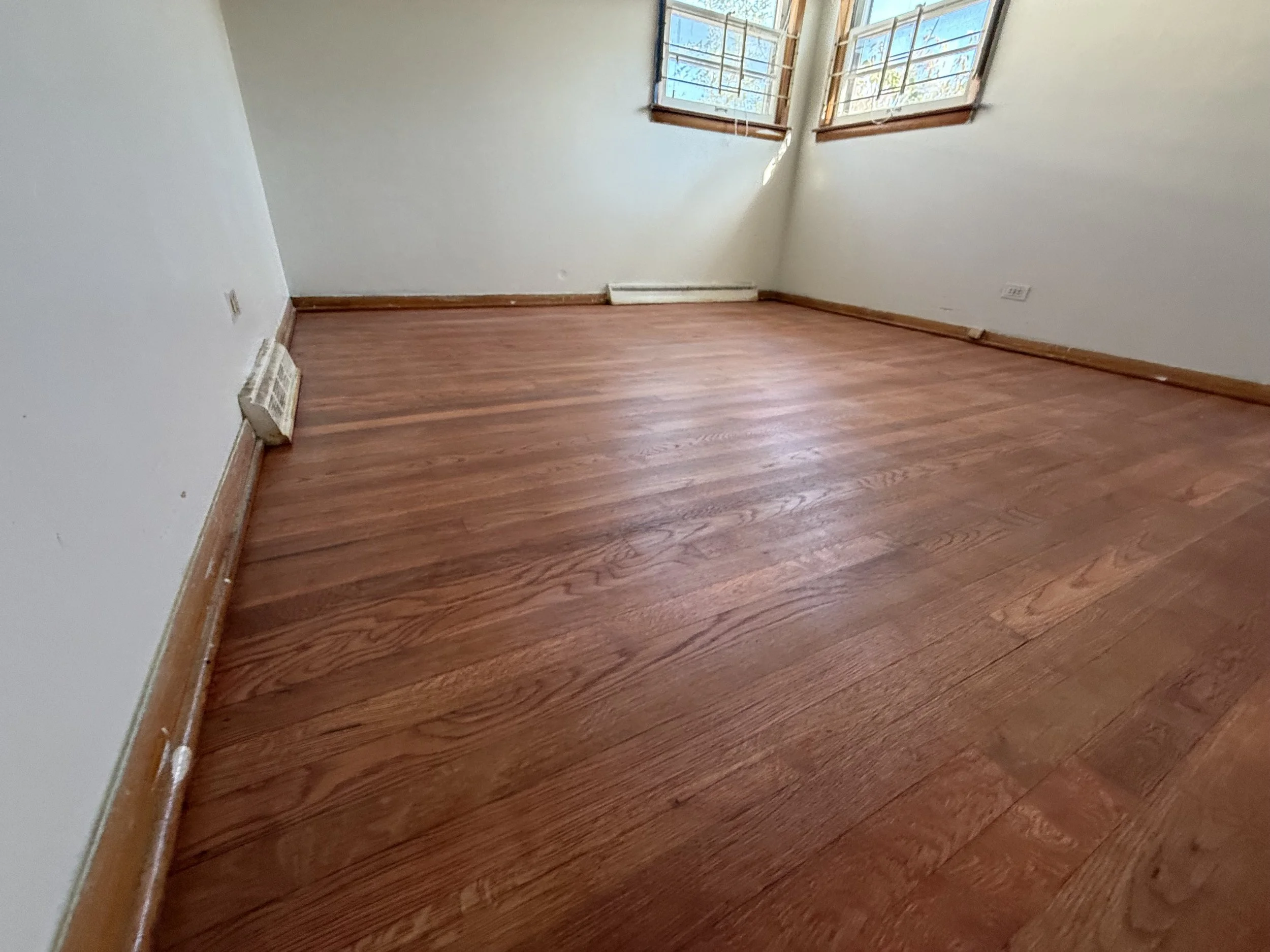 Refinished hardwood floor with renewed natural color and a durable protective finish in a Bridgeview home