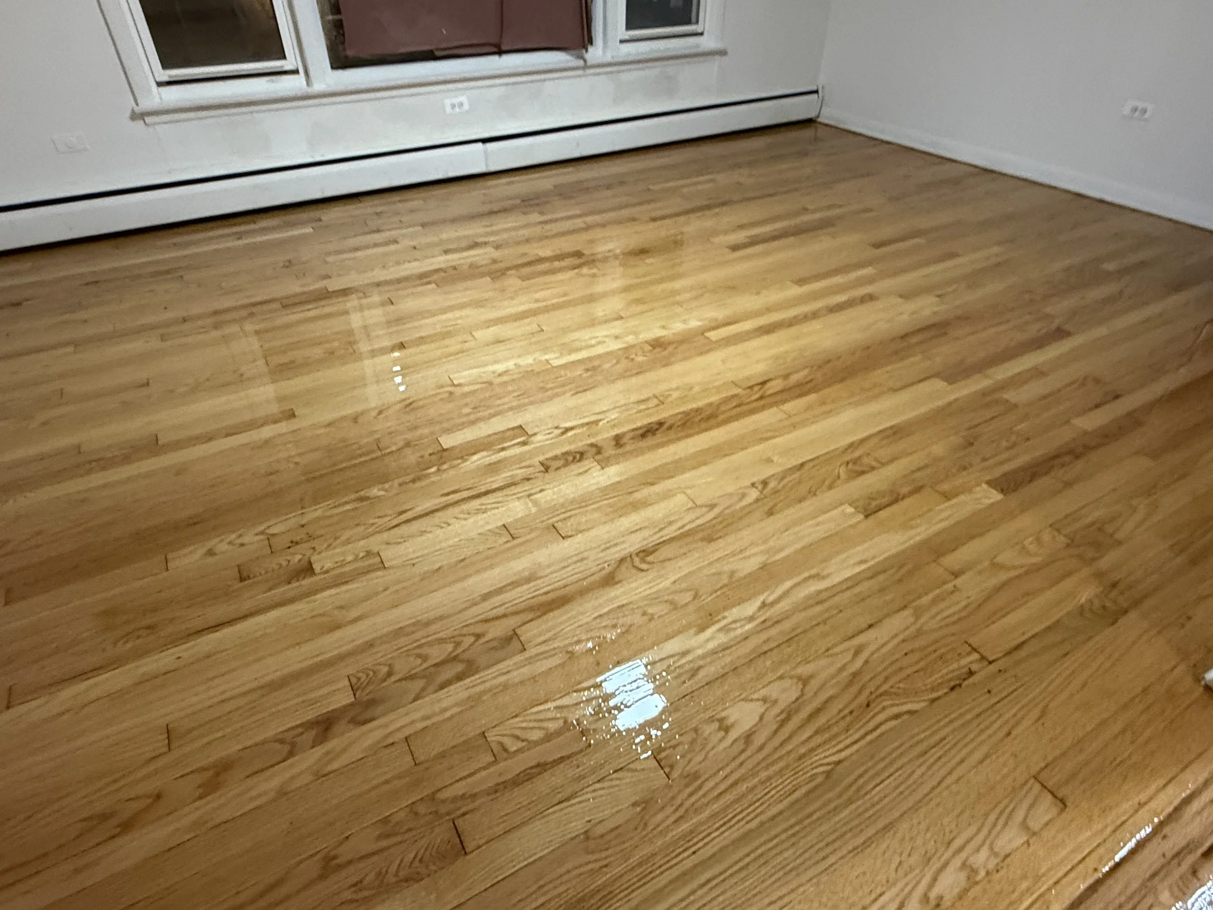 Refinished hardwood flooring with renewed natural color and durable protective finish in a Palos Hills home