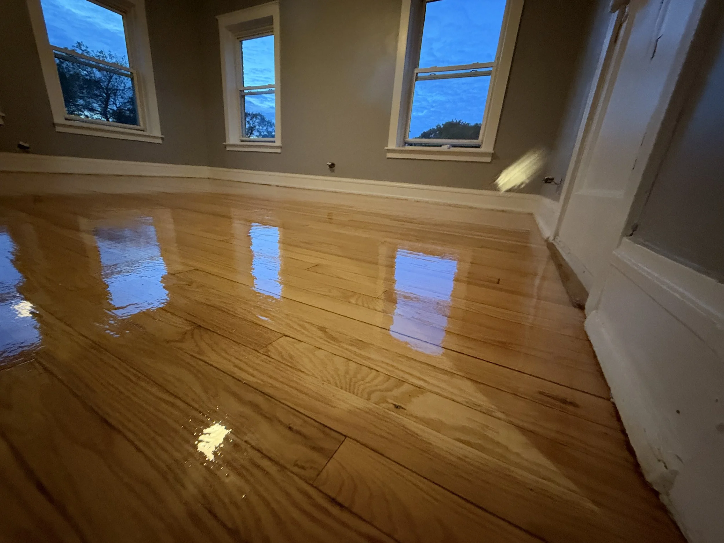 Refinished hardwood flooring with a smooth even surface and durable protective finish in an Oswego home