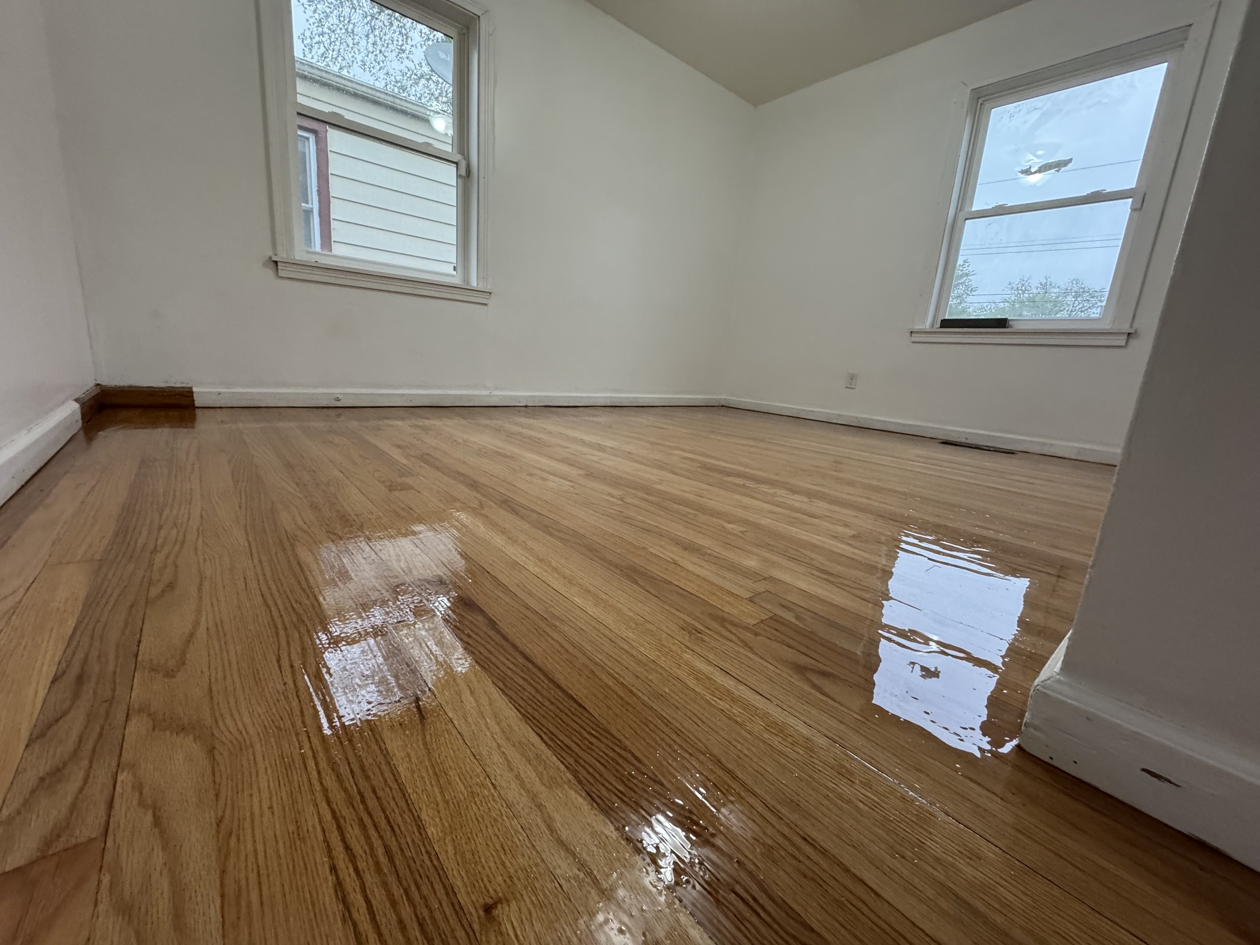 Refinished hardwood flooring with a smooth renewed appearance and durable protective finish in a Channahon home