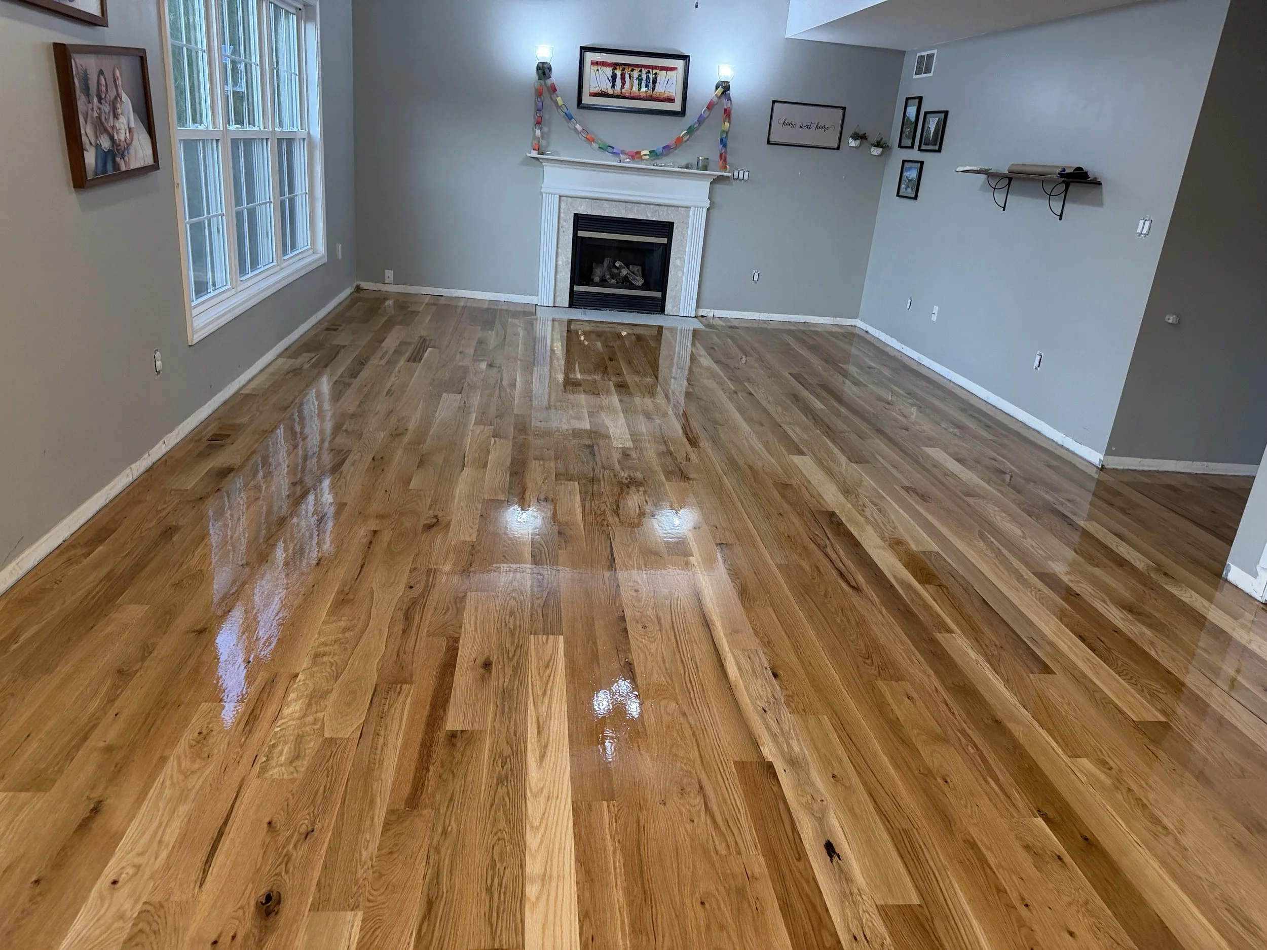 Hardwood flooring refinished with renewed color, visible natural grain, and a protective topcoat