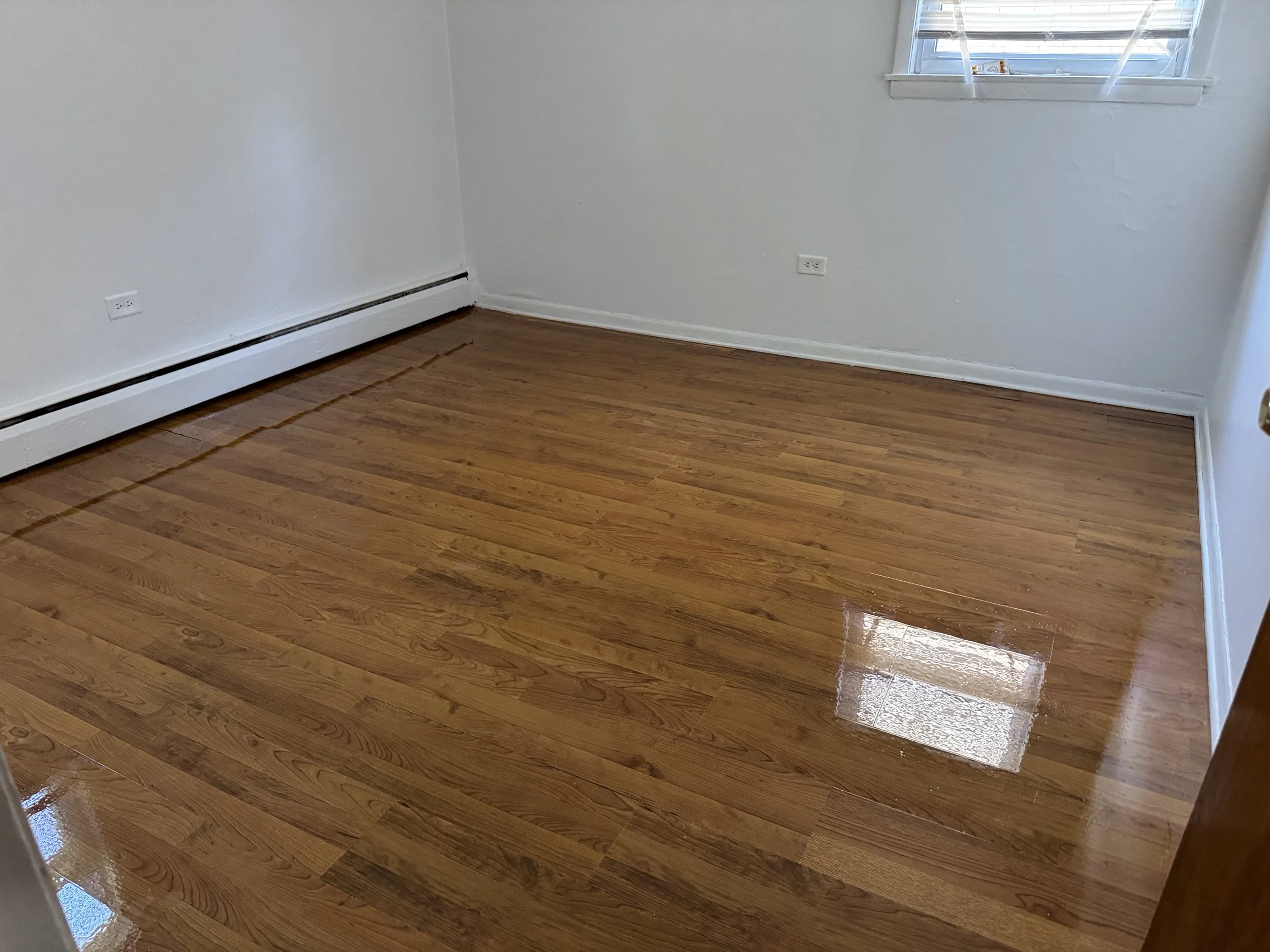 Refinished hardwood flooring with renewed natural color and durable protective finish in a Glenwood home
