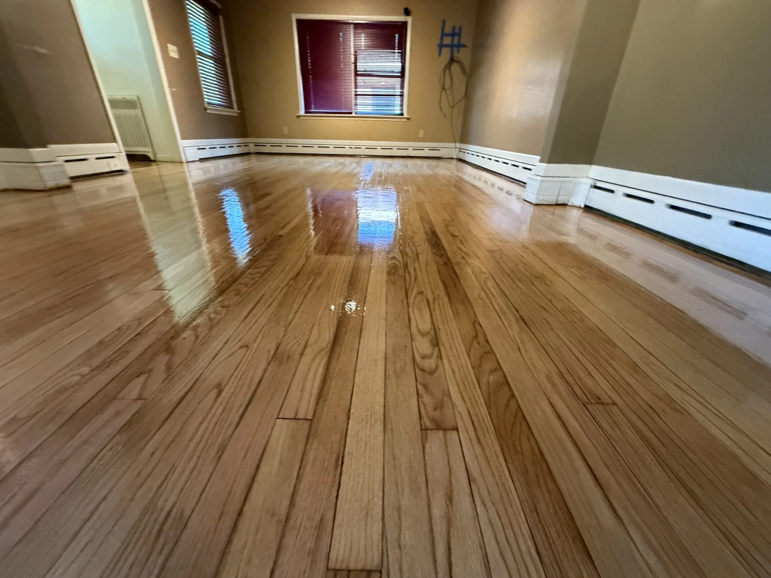 Refinished hardwood flooring with renewed natural color and a durable protective finish in a Sleepy Hollow home