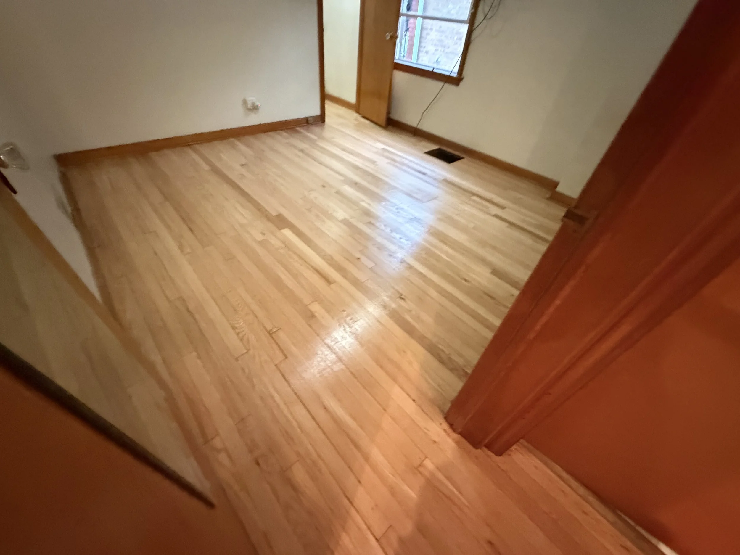 Refinished hardwood floor with restored natural color and durable protective finish in a Countryside home