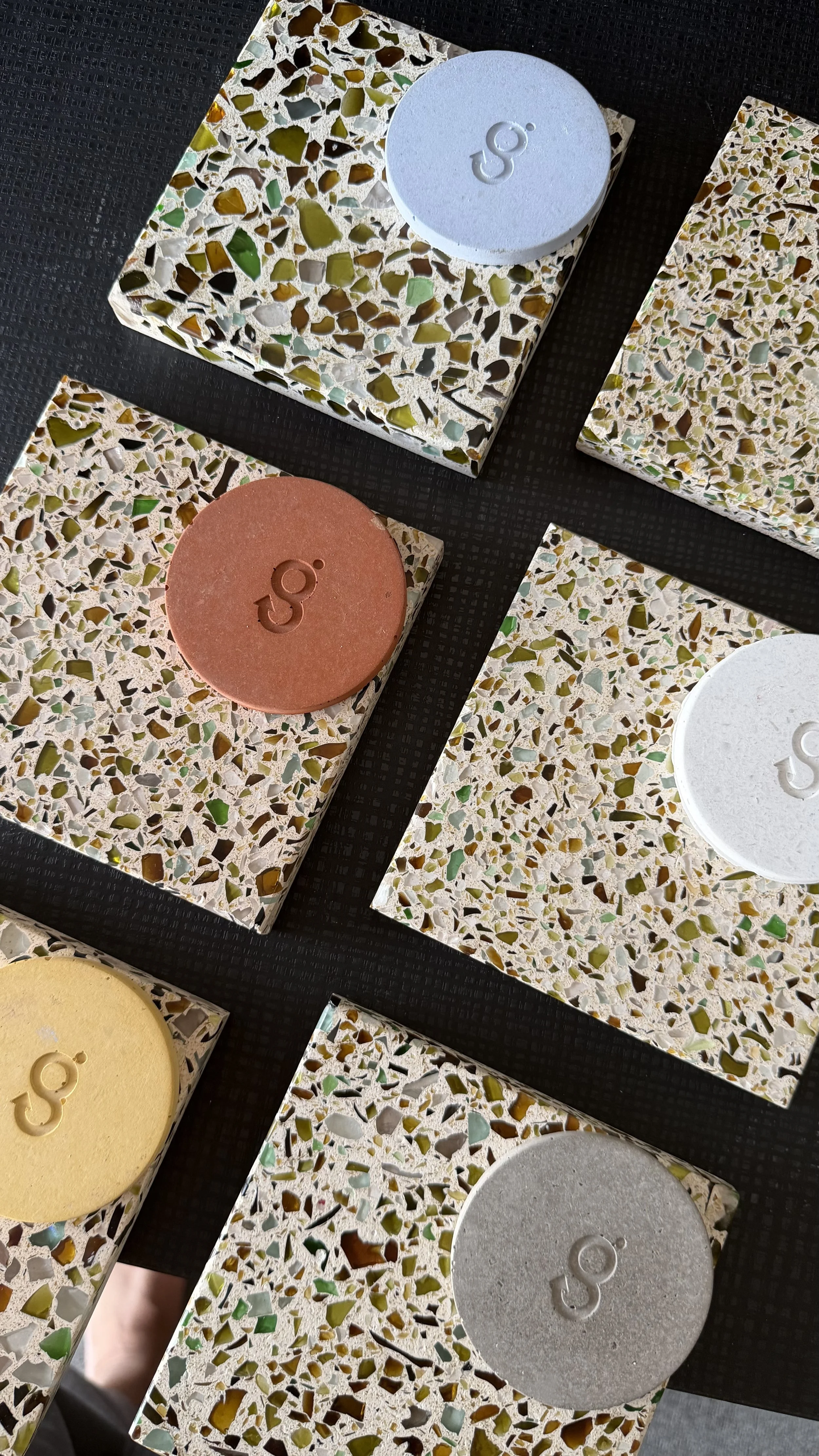 Close-up of terrazzo tiles with round, colored tiles on top featuring the Google 'G' logo.