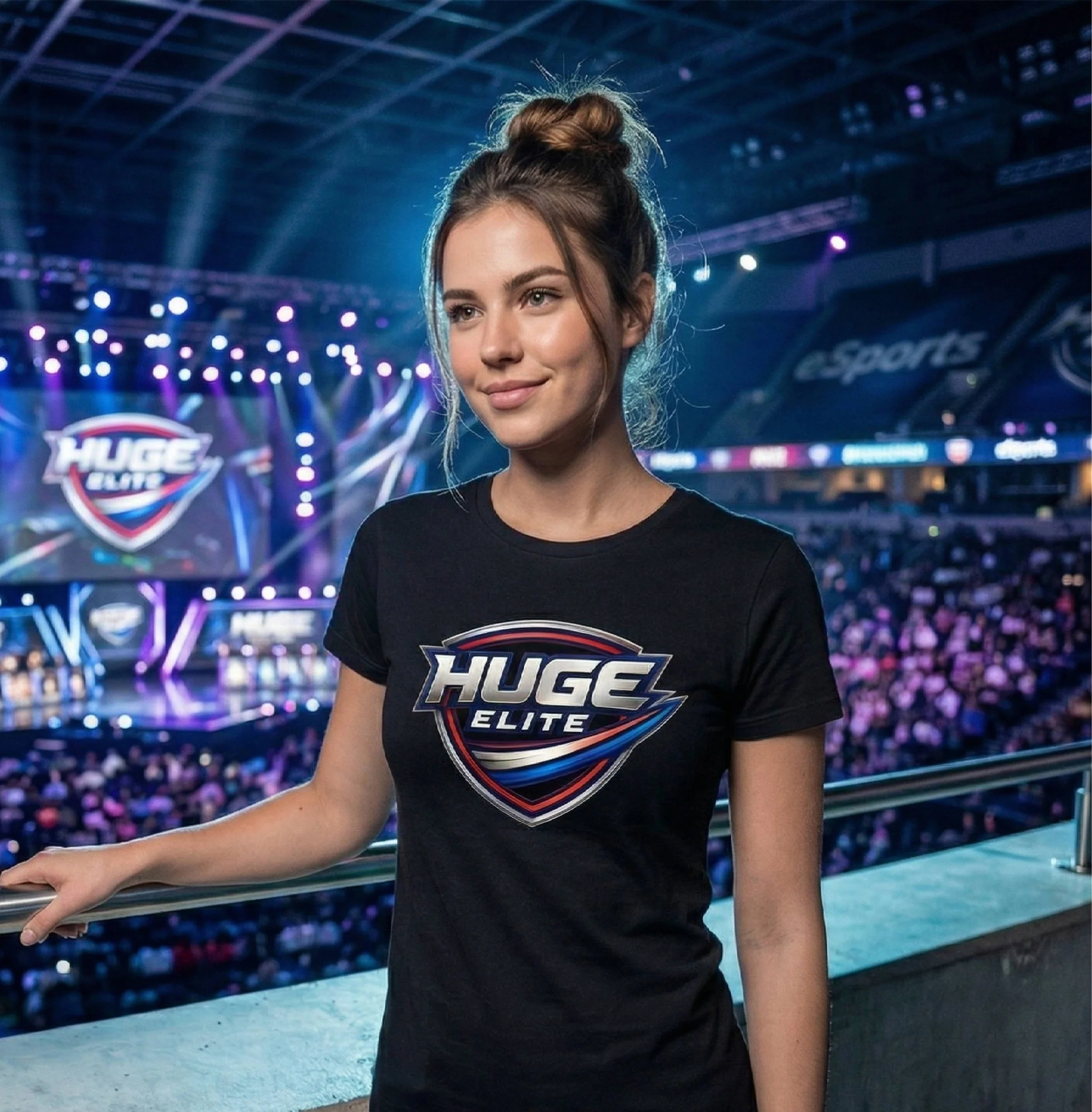 A young woman with light skin and long brown hair in a bun, wearing a black T-shirt with the 'HUGE ELITE' logo, standing by a railing at a sports arena with bright lights and a crowd in the background.
