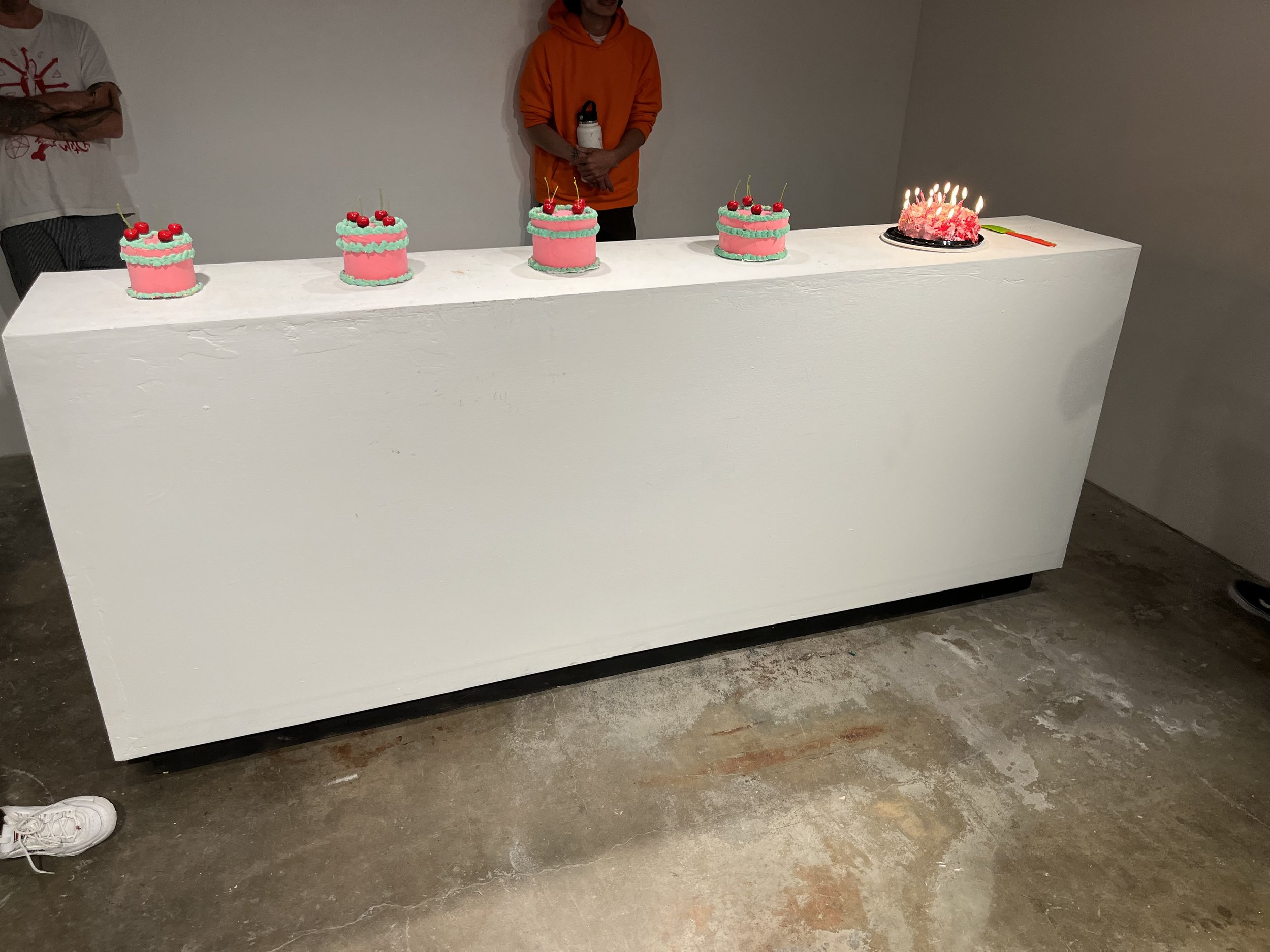 Poundcake, 2023, cardboard base, spackle, acrylic paint, faux cherries, candles, spatula