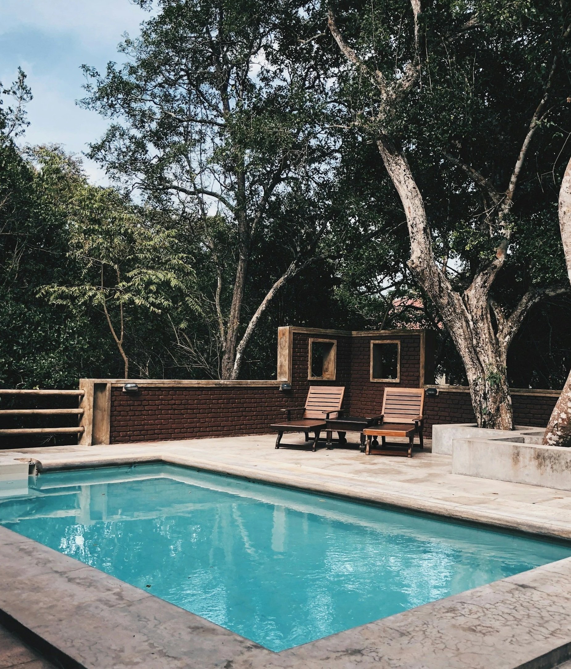 inground fiberglass pool set in a resort style backyard