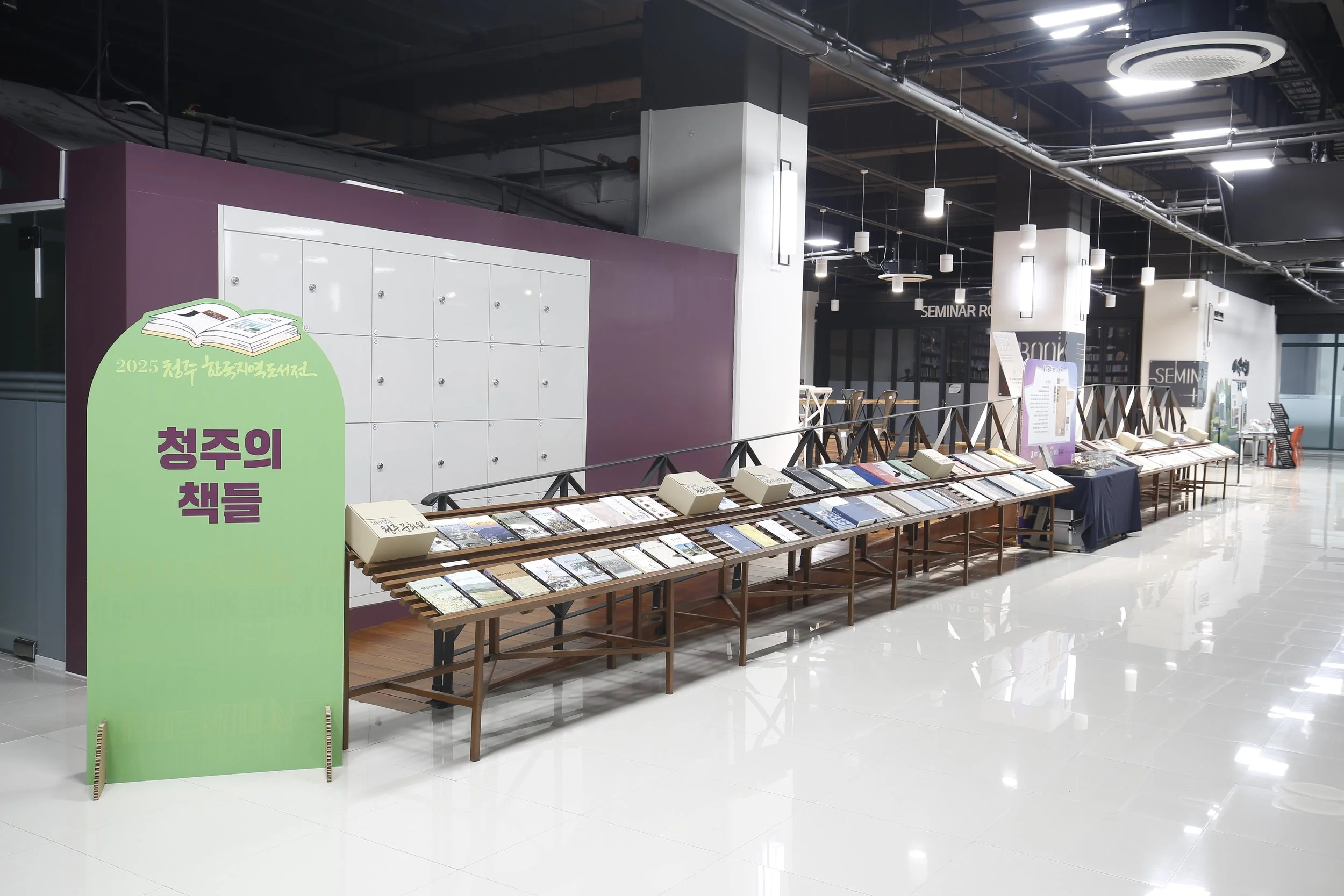 서점 내부에 책과 잡지를 전시하는 전시대가 놓여 있고, 배경에는 책방 구역이 보인다.