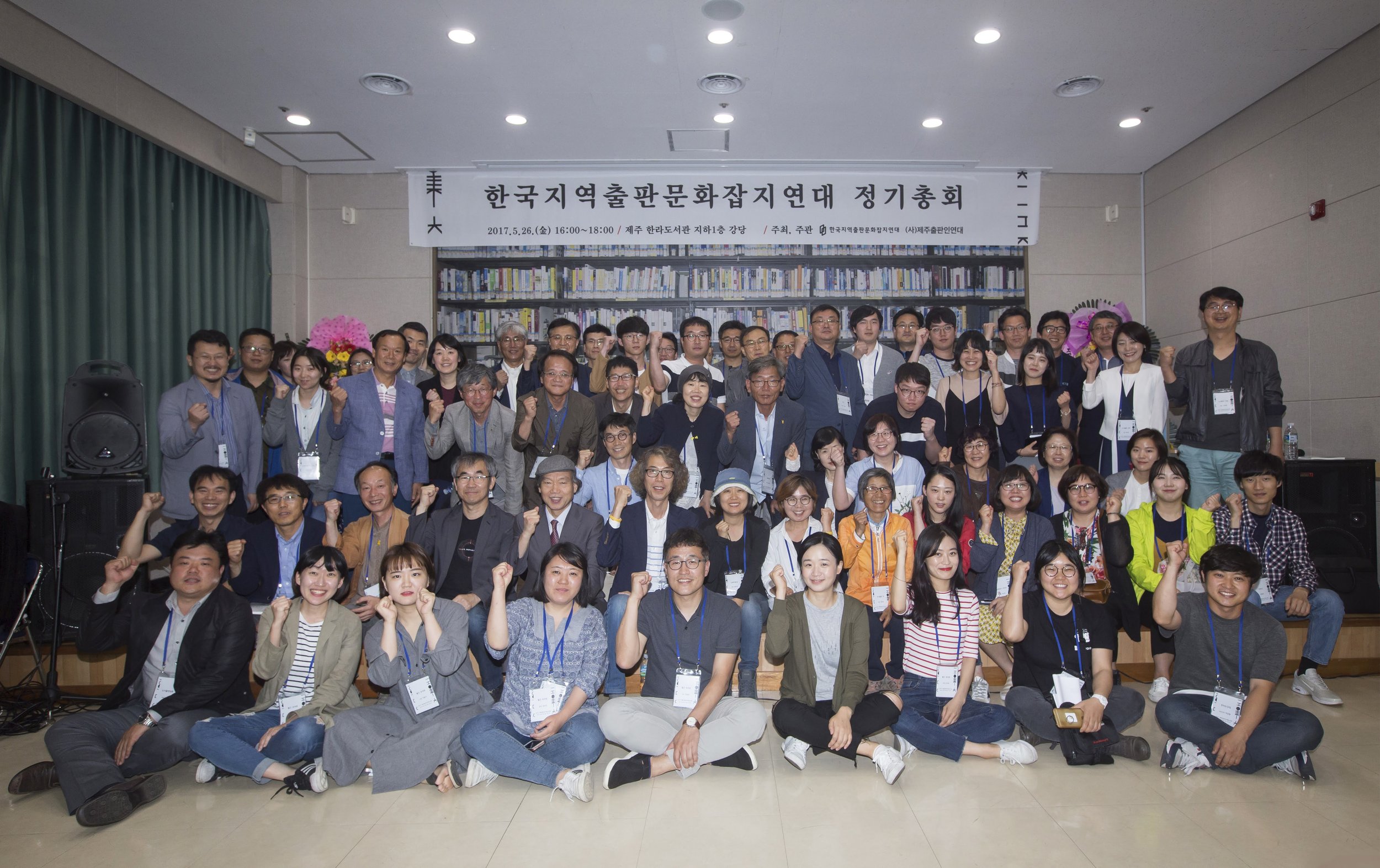 한국지역출판문화잡지연대 정기총회 사진으로, 많은 사람들이 모여서 사진을 찍고 있으며, 배너에는 '한국지역출판문화잡지연대 정기총회'라고 적혀 있습니다.