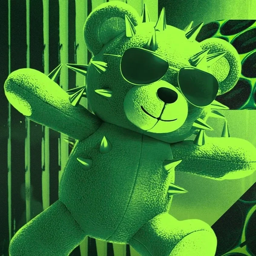 A teddy bear wearing sunglasses with spikes on its head, sitting against a green background.
