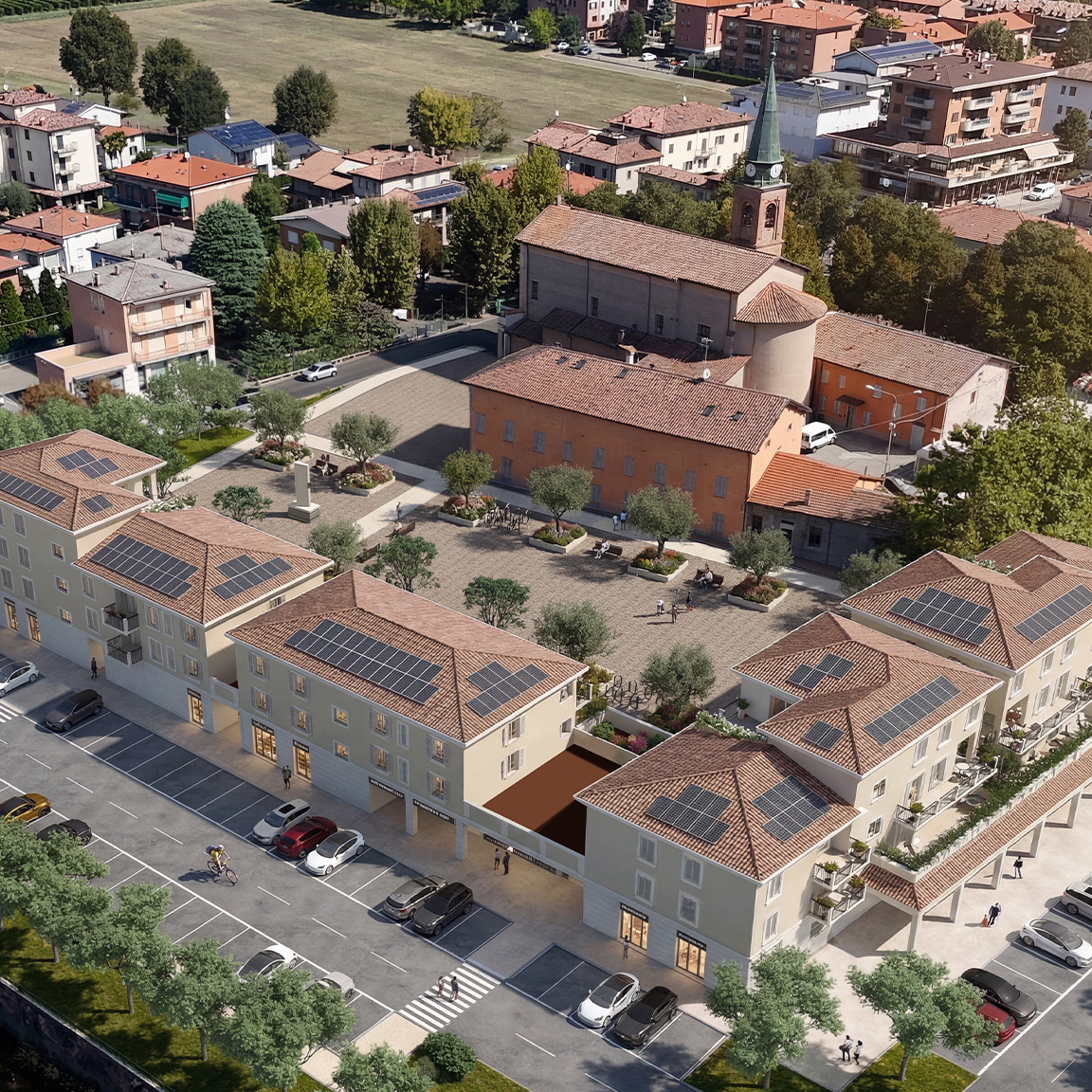 Prospettiva aerea di un centro storico con chiesa, piazza con panchine e alberi, case con pannelli solari e parcheggi. Magreta Modena piazza Kennedy