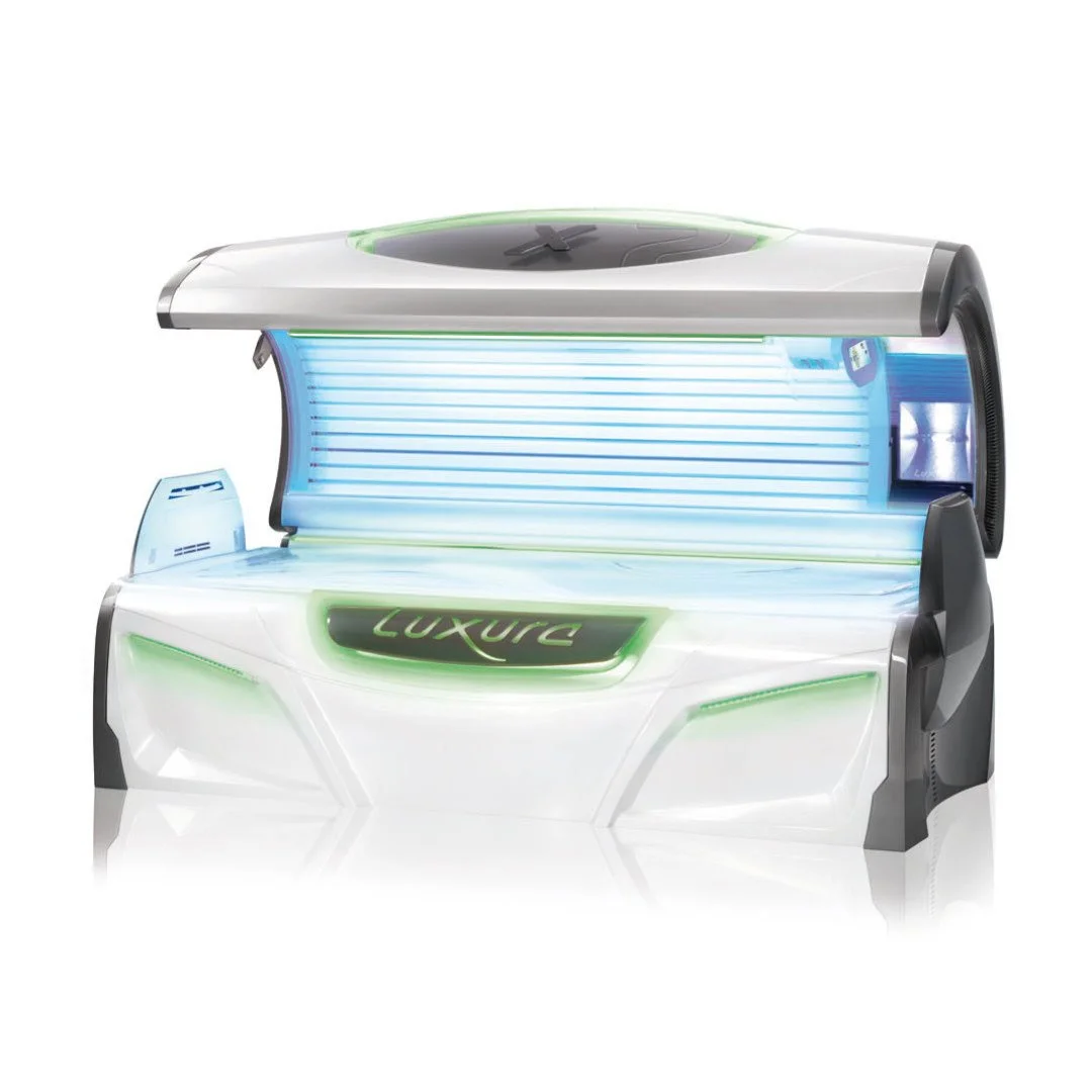 A futuristic tanning bed with open lid, illuminated with blue and green lights, featuring the word 'Luxury' on the front.
