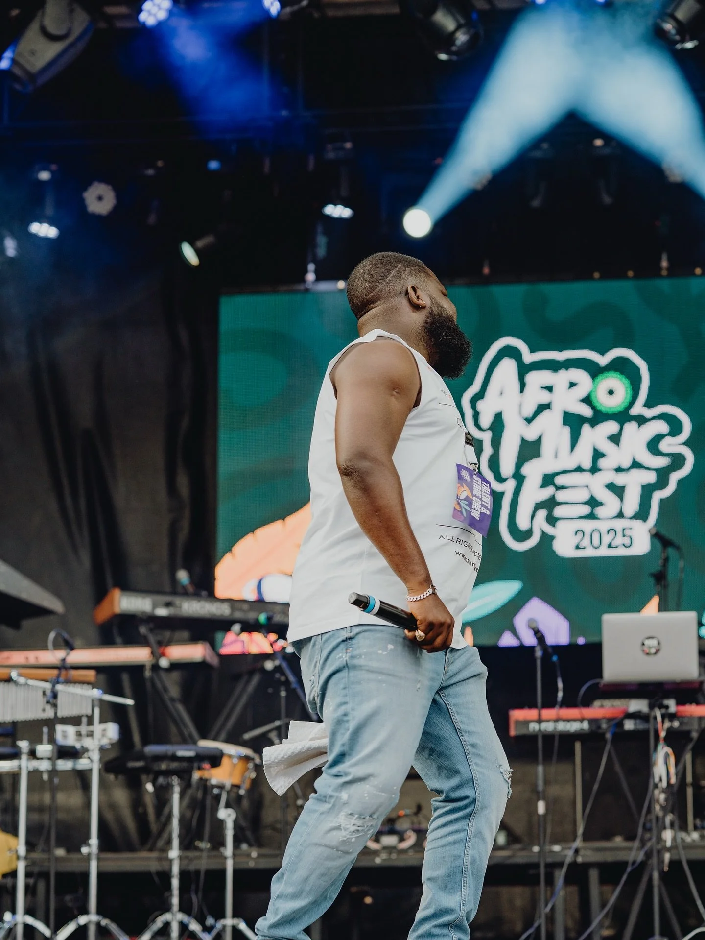 A man with a beard holding a microphone on stage at Aero Music Fest 2025.
