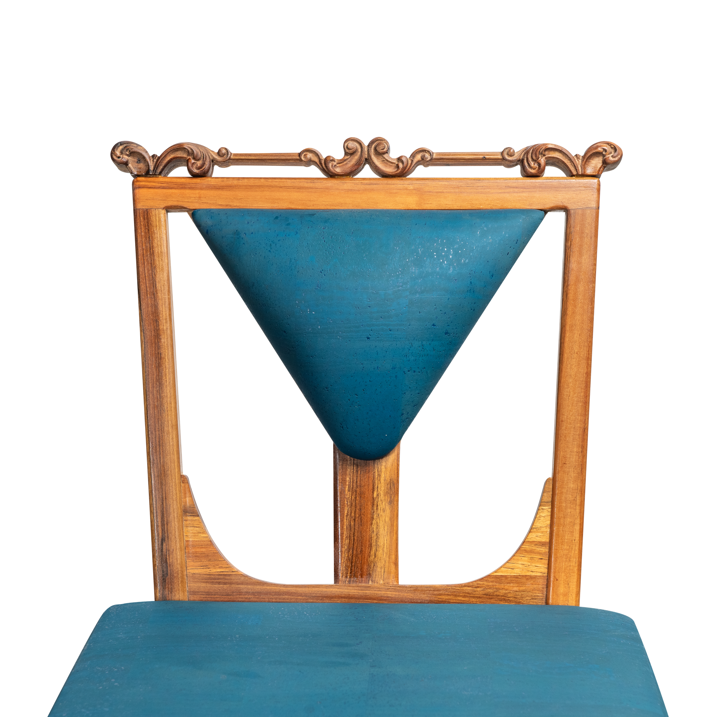 A wooden picture frame with ornate carvings at the top, holding a blue ceramic bowl, placed on a teal surface.