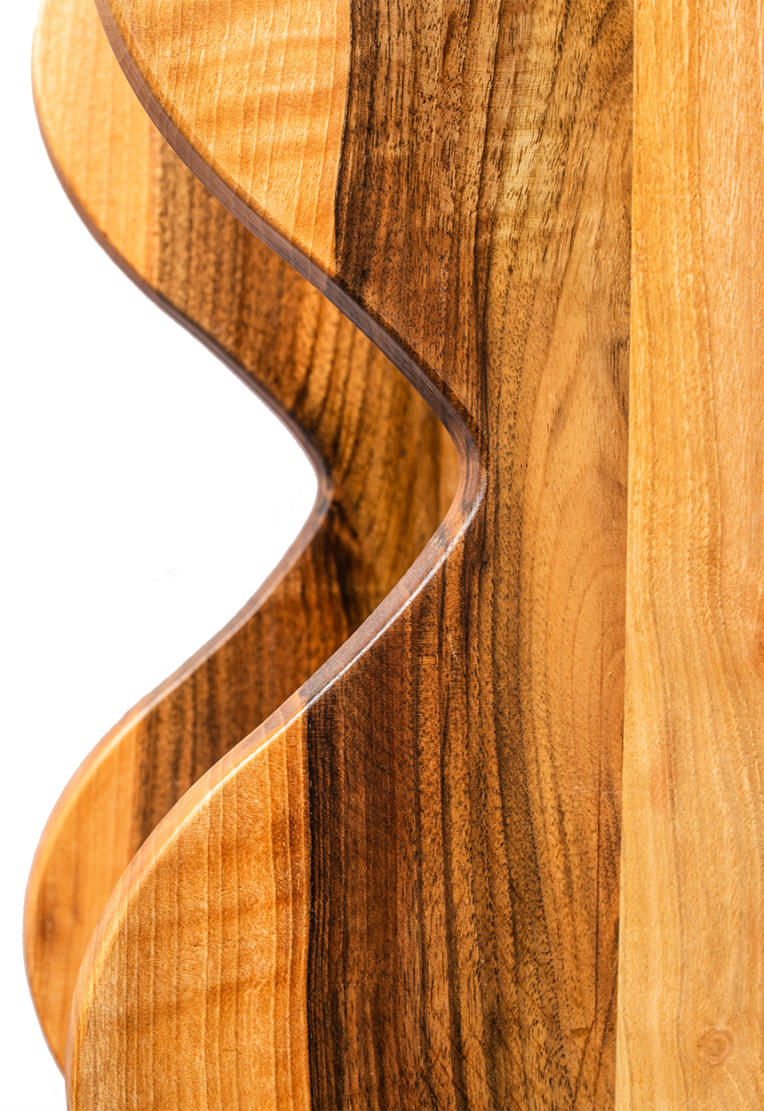 Close-up of a wooden decorative object with a curved, wave-like cutout