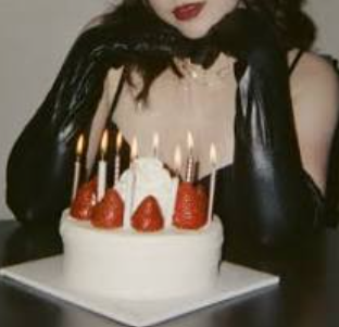 Celine in long black latex gloves posing with a cake. Sexy London escort food play, birthday party. Dom sploshing escort in London. Sexy birthday girl.