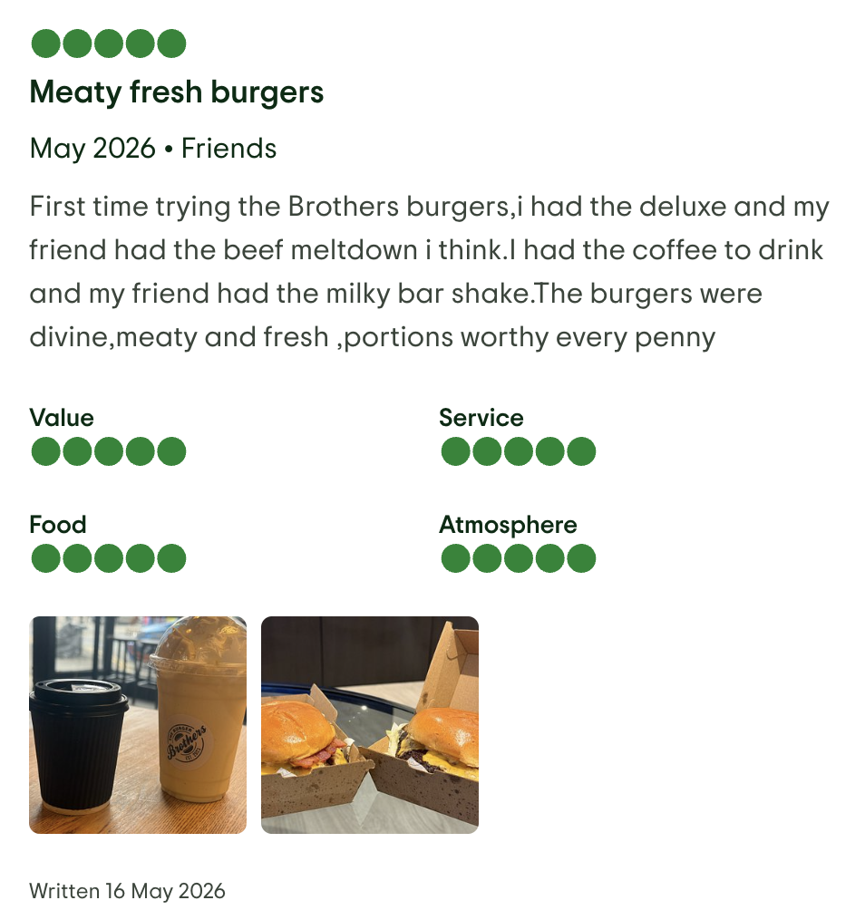 A review of a burger joint including a photo of two burgers and two drinks on a table at a restaurant.