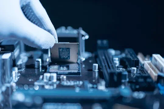 Close-up of a hand installing a CPU onto a computer motherboard.