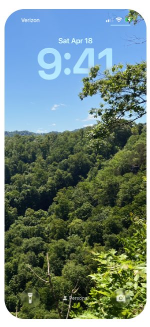 Phone screen showing a landscape with green trees and a blue sky on Saturday, April 18 at 9:41 AM.