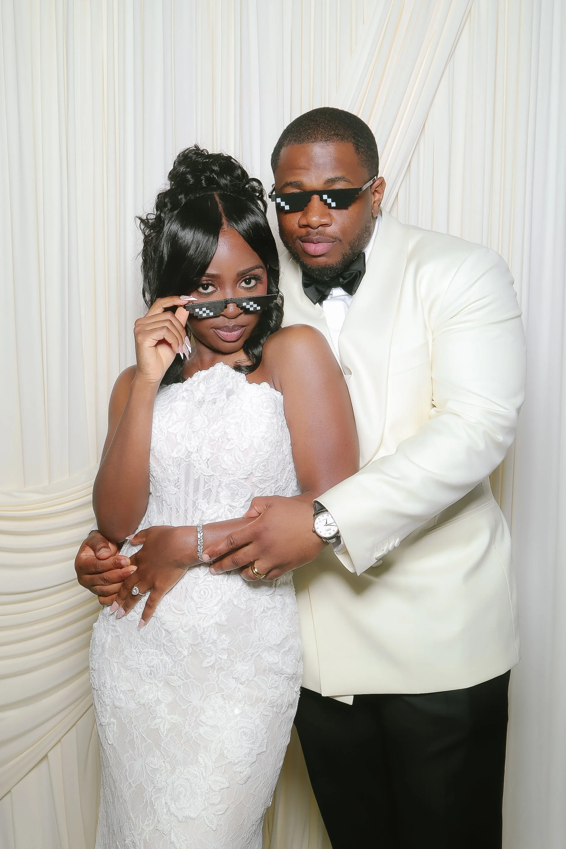 Bride and groom posing in sunglasses against an ivory drape backdrop with Bella’s Retro Mirror Photobooth in metro Atlanta.