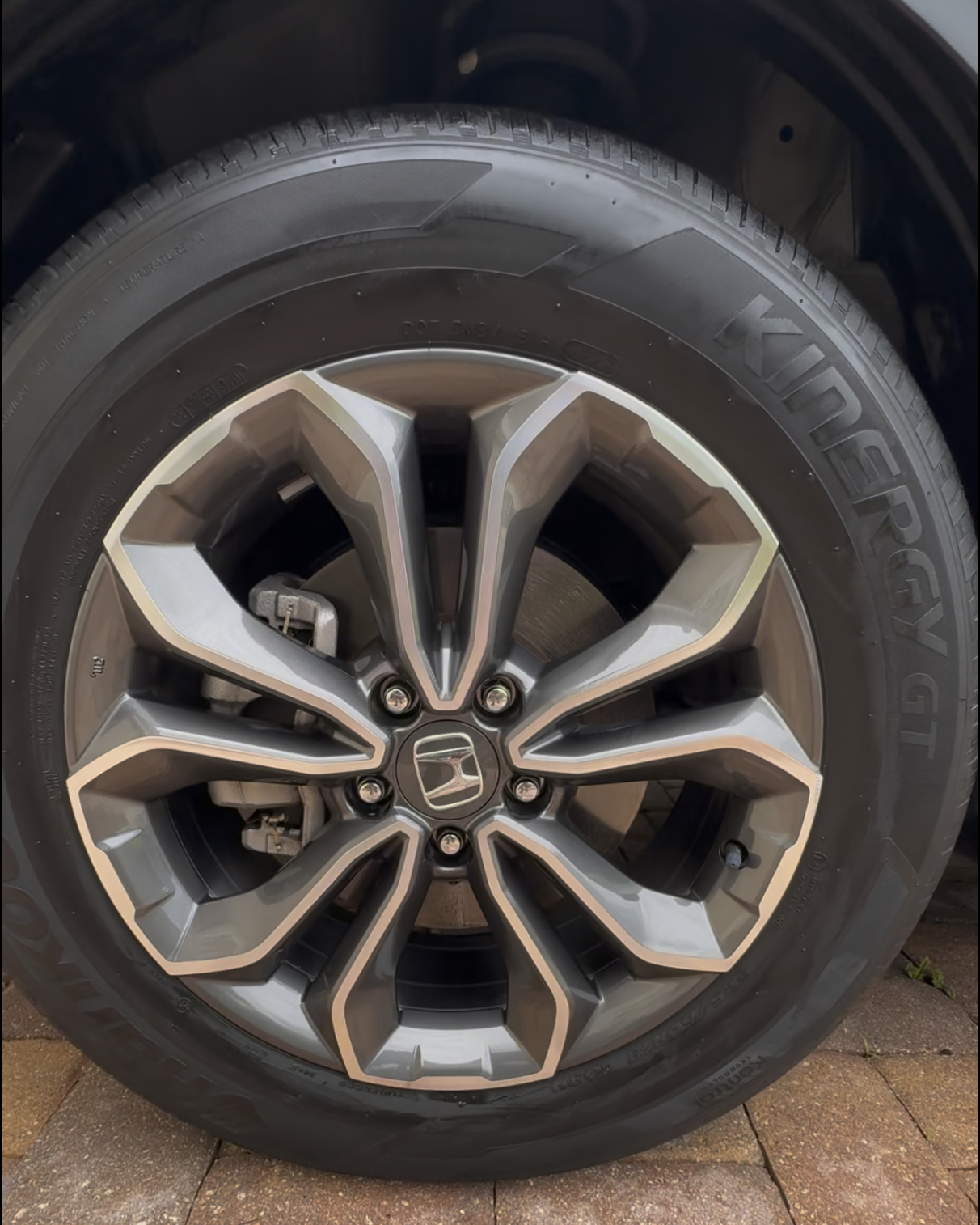 Close-up of a Honda car wheel with a detailed alloy rim and a Goodyear tire on a paved surface.